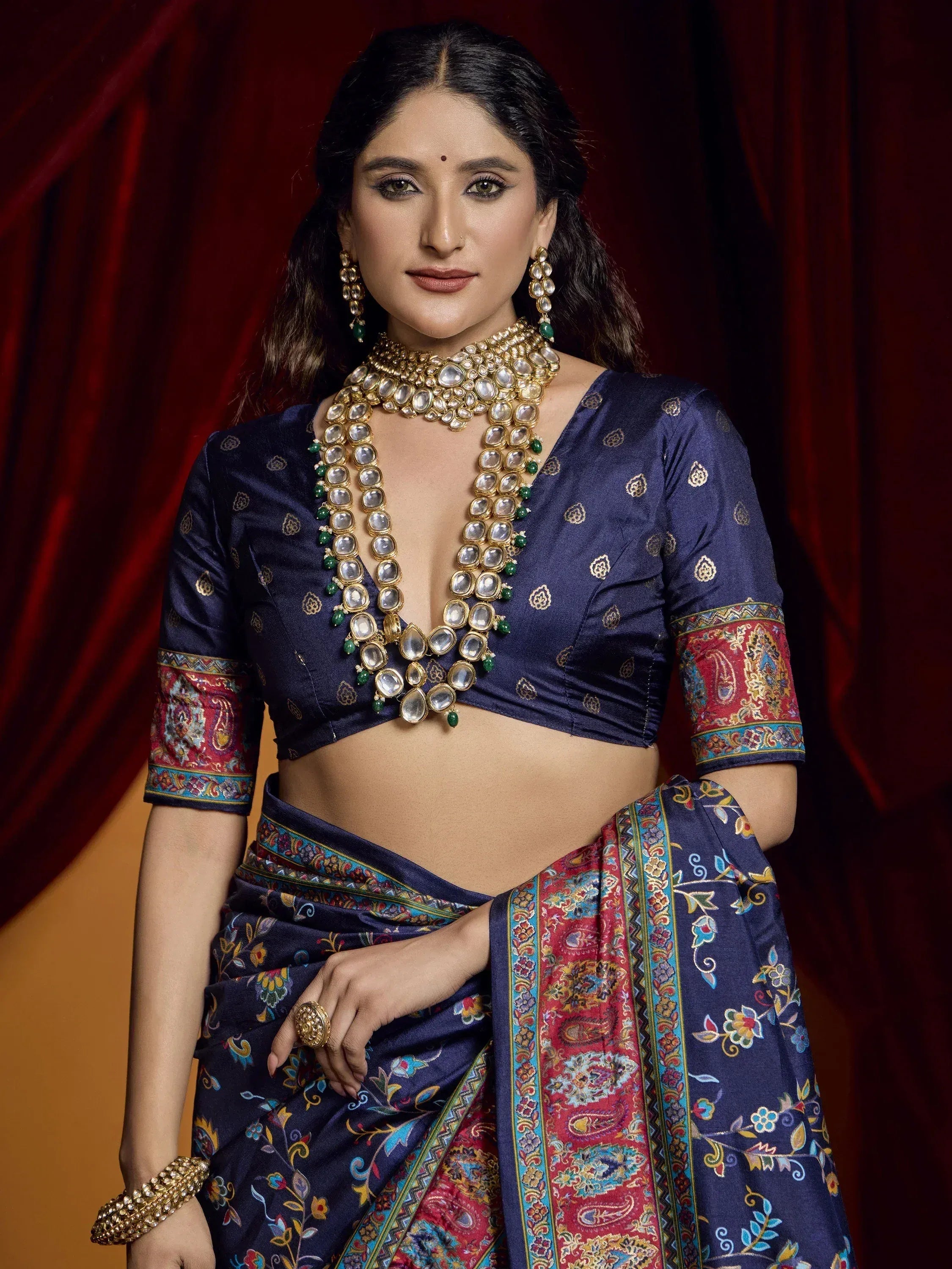 Woman in navy blue printed saree with gold jewelry, perfect for Indian ethnic wear occasions