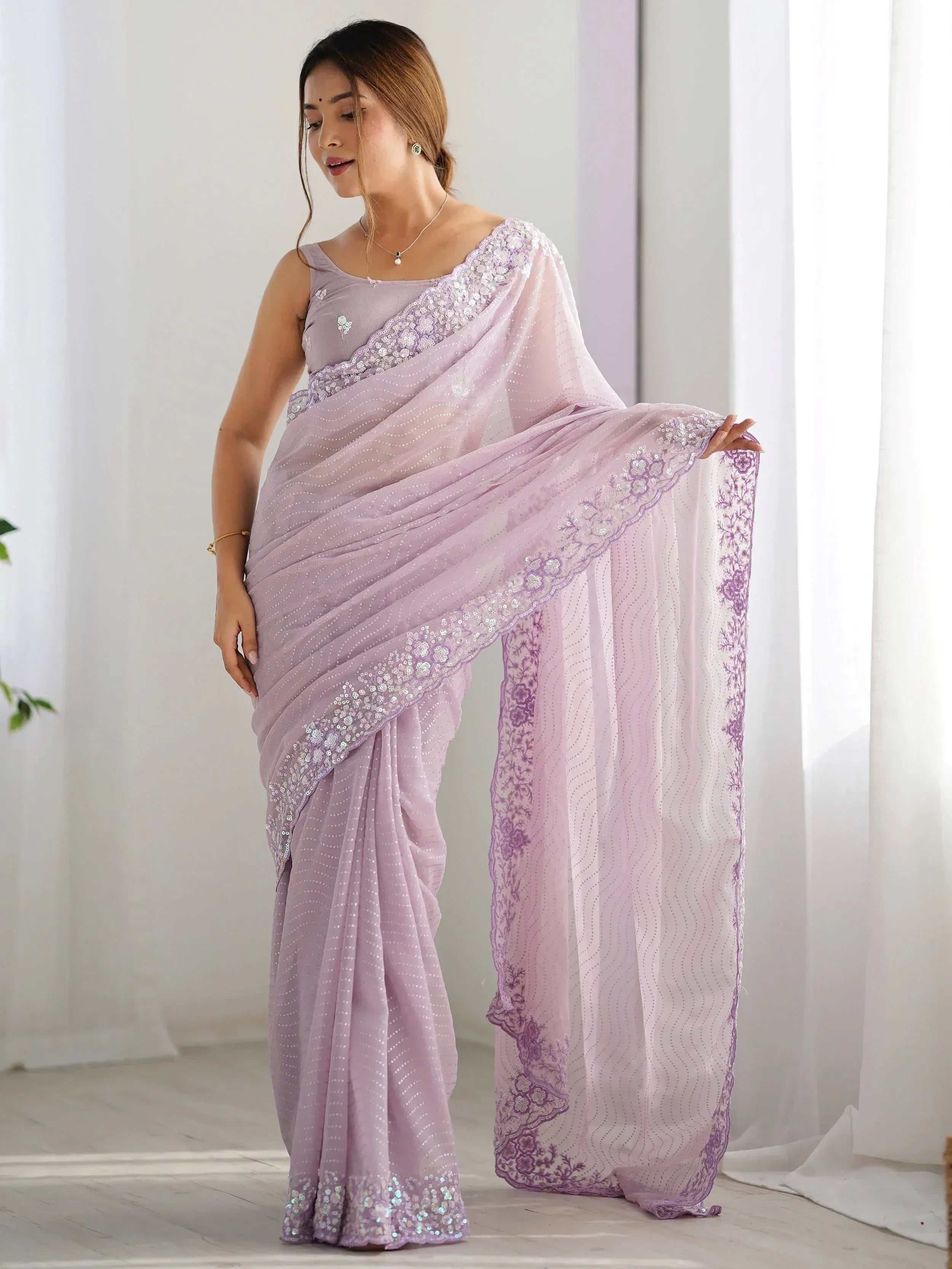 Lavender designer saree with sequin embroidery and floral border, perfect for ethnic occasions.