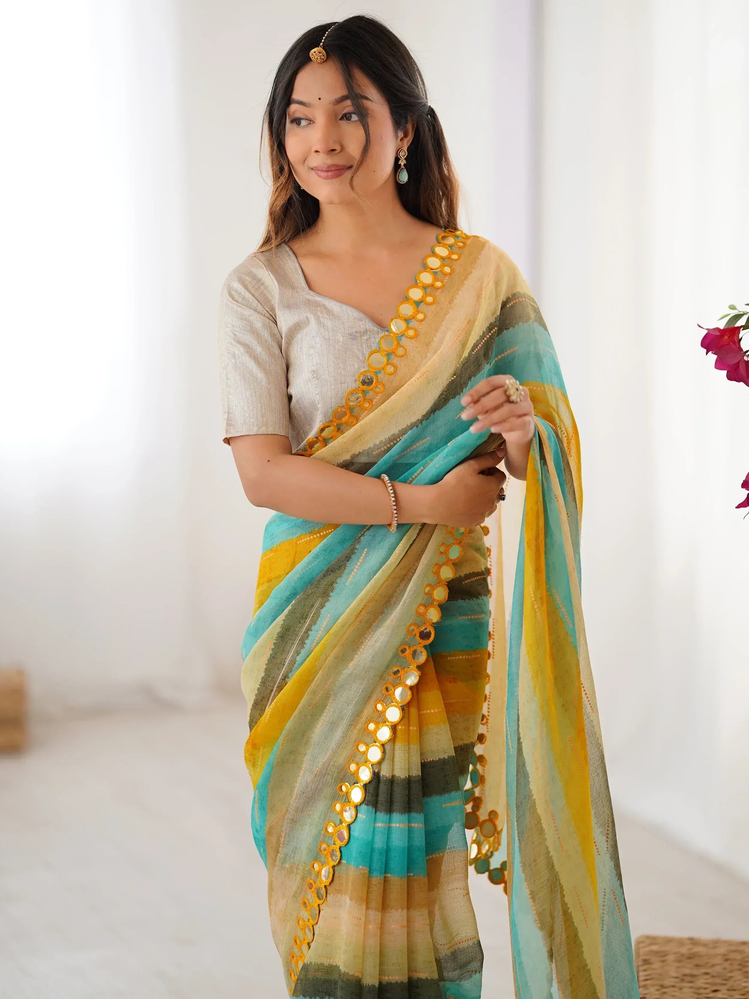 Woman wearing colorful ethnic saree with mirror work, perfect for Indian occasions and festive wear.