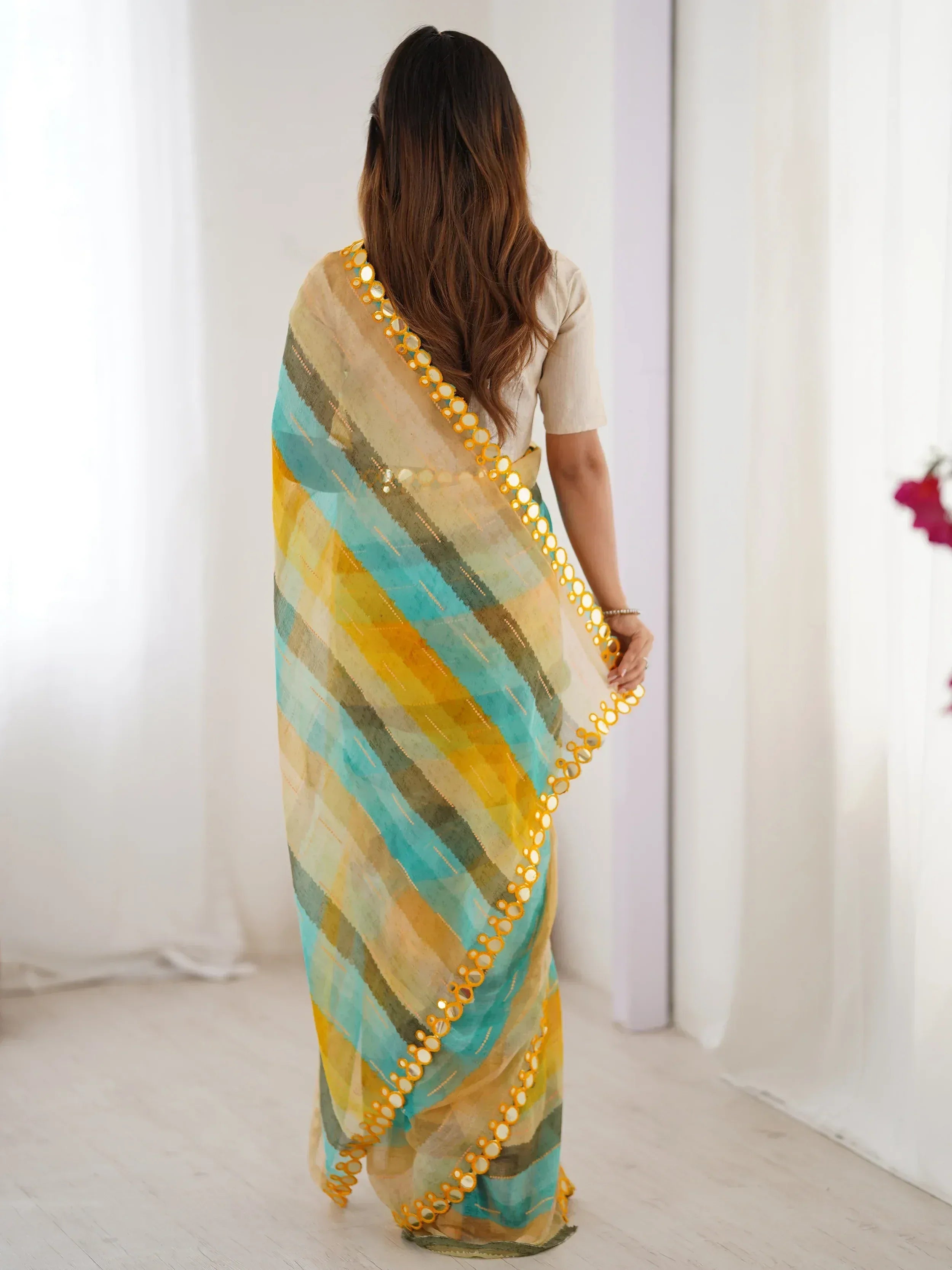 Woman wearing colorful striped saree with mirror work border, ethnic Indian wear