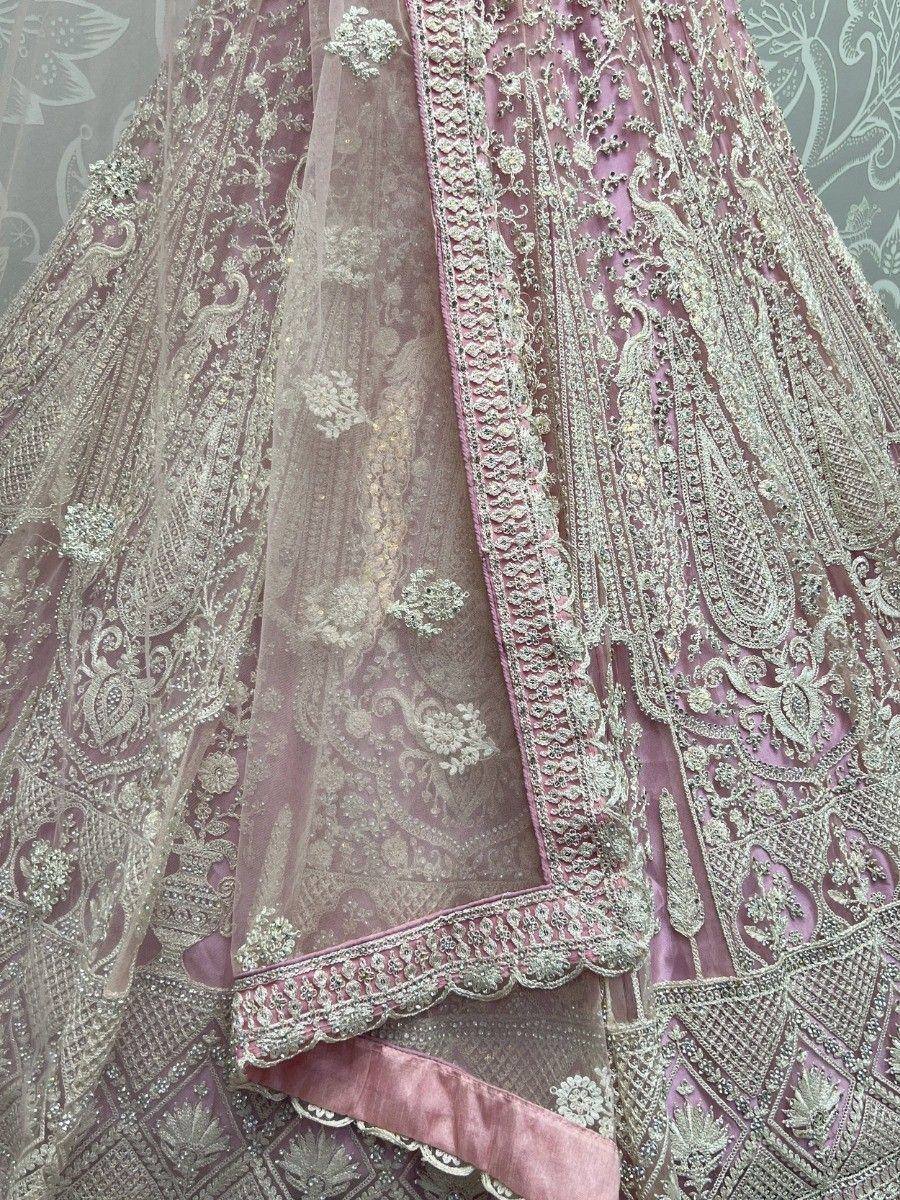 Pink designer lehenga choli with intricate gold embroidery and sheer dupatta, perfect for Indian weddings