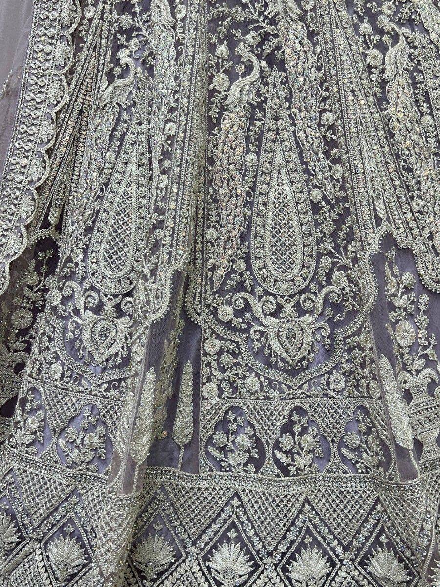 Luxury Indian lehenga with intricate gold embroidery and peacock motifs on sheer fabric