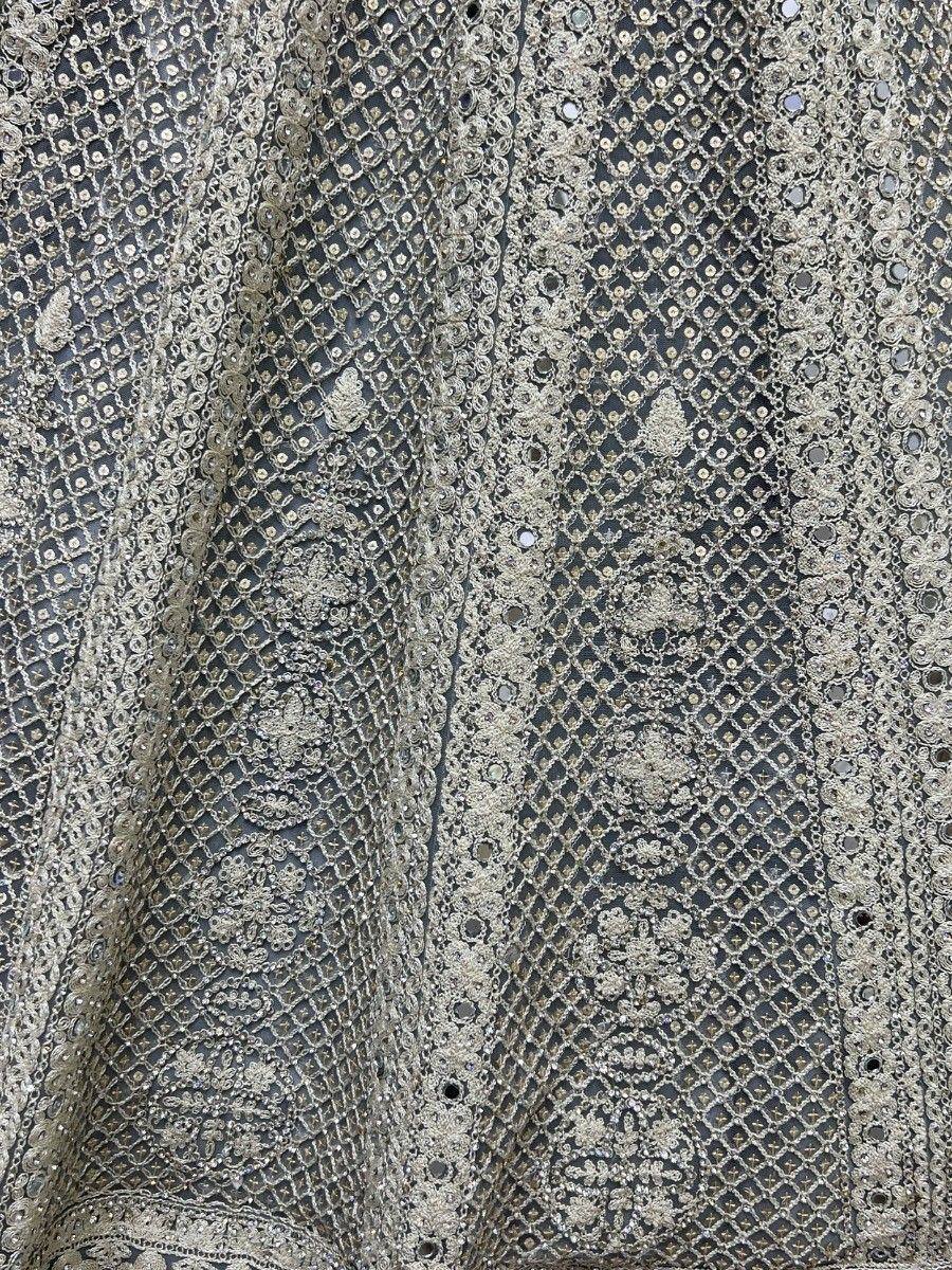 Exquisite silver embroidery with mirror work on dark fabric, perfect for designer lehenga choli or ethnic gown.