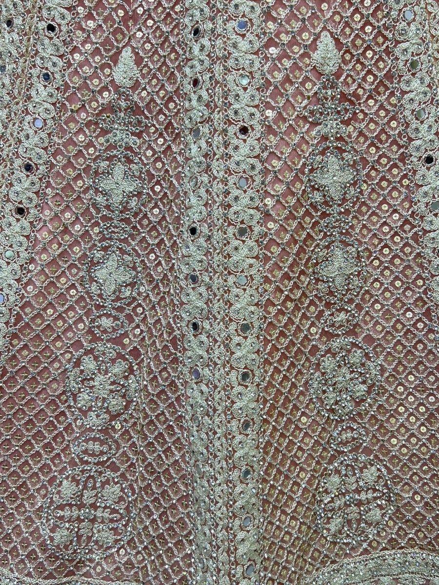 Intricate silver embroidery and mirror work on dusty rose ethnic fabric, perfect for designer lehenga choli or saree.
