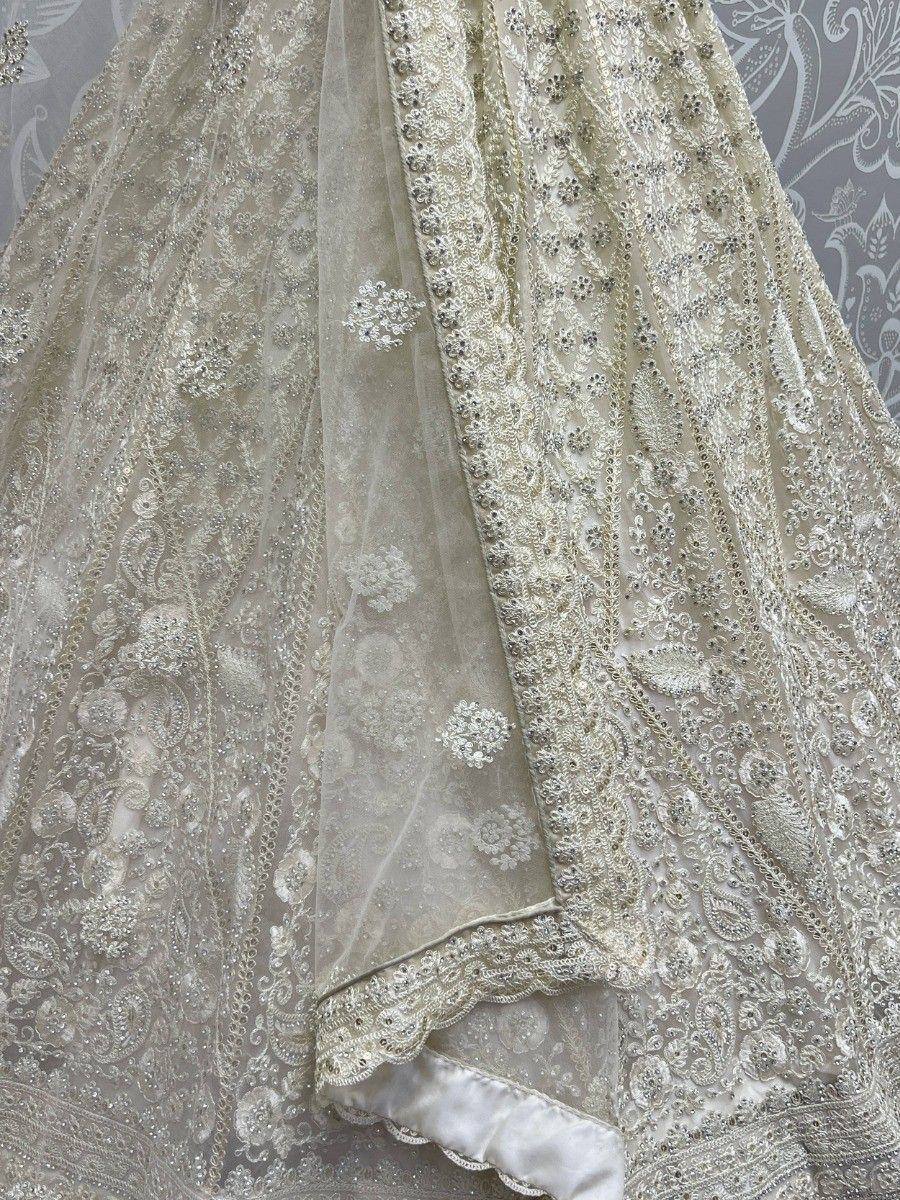 Elegant ivory lehenga choli with intricate embroidery and sequin work, perfect for weddings and festive occasions.