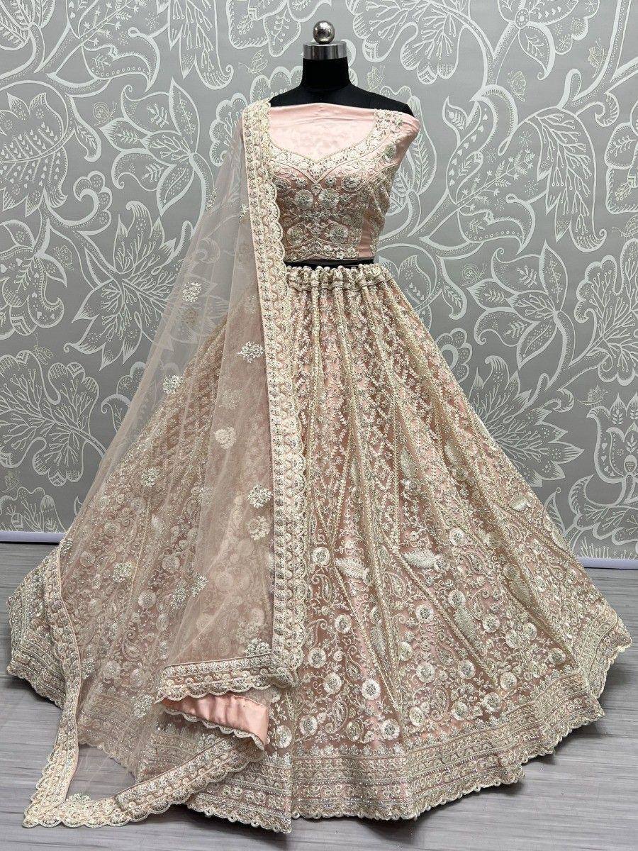 Elegant blush pink lehenga choli with intricate gold embroidery and matching dupatta, perfect for weddings and festive occasions.