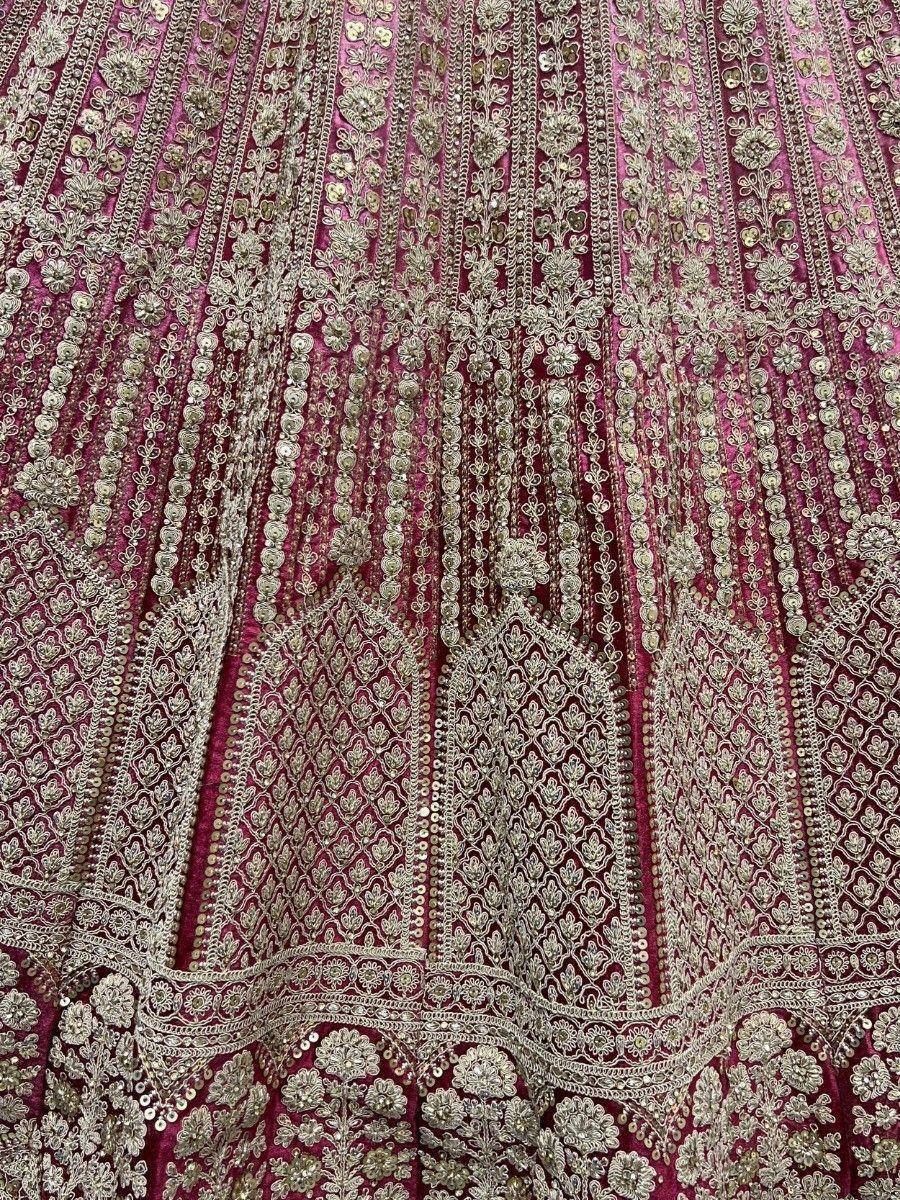 Luxury maroon lehenga with intricate gold embroidery and sequin detailing, perfect for Indian weddings and festive occasions.