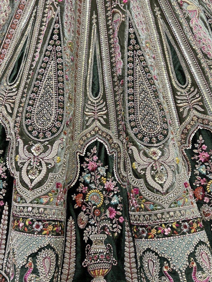 Dark green velvet lehenga with intricate floral and paisley embroidery, perfect for Indian ethnic wear.
