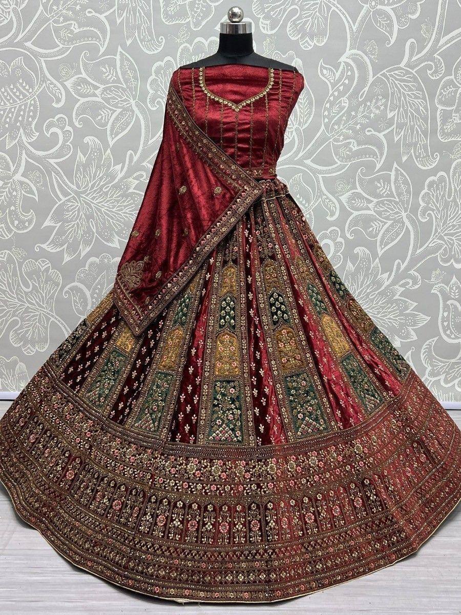 Rich maroon designer lehenga choli with intricate gold and green embroidery, perfect for weddings and festive occasions.
