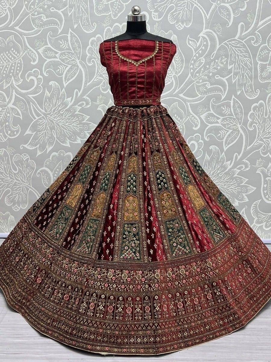Maroon designer lehenga choli with intricate gold and green embroidery, perfect for Indian weddings and festive occasions.