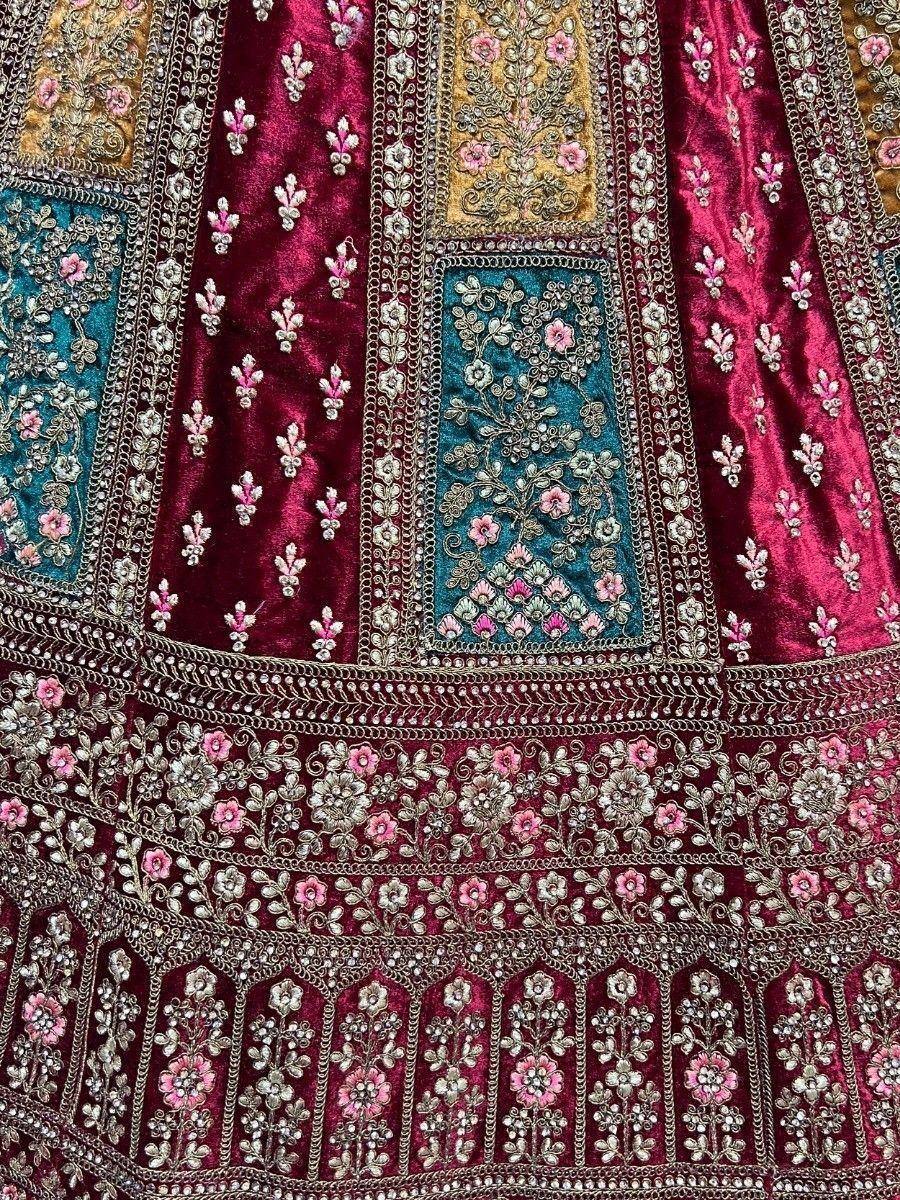 Luxury maroon velvet lehenga with intricate floral embroidery and patchwork detailing