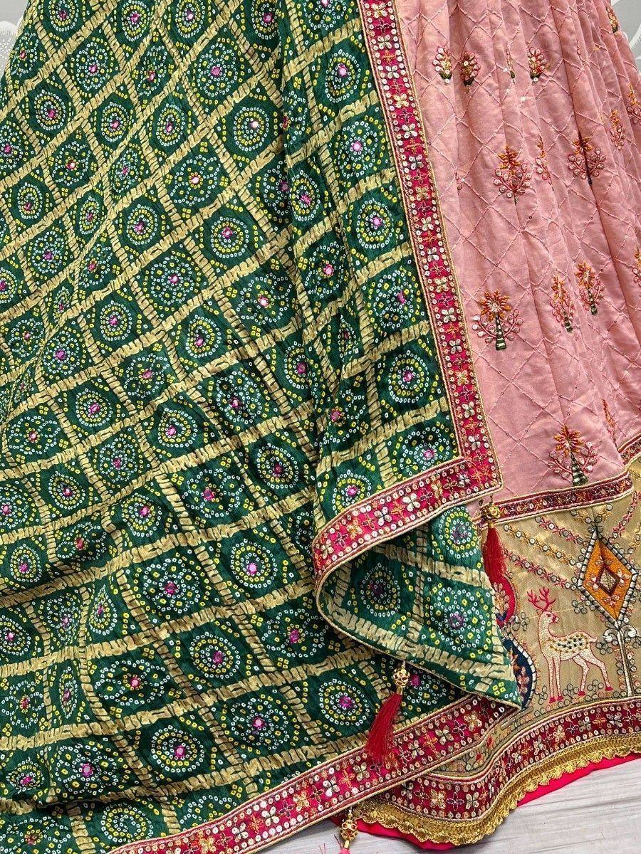 Green and pink embroidered lehenga choli with intricate mirror work and floral motifs, perfect for Indian ethnic wear.