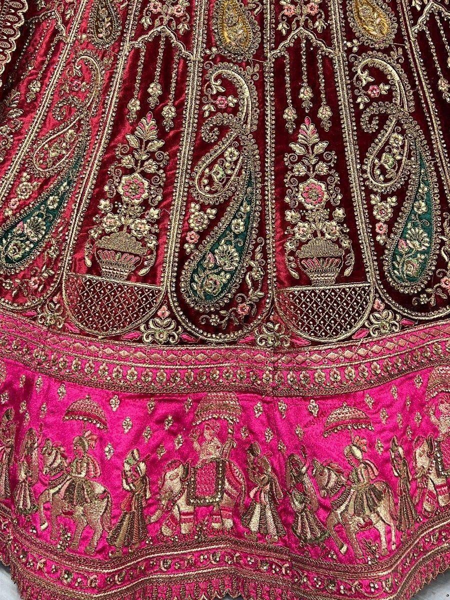 Luxury maroon and pink velvet lehenga with intricate gold embroidery and royal motifs