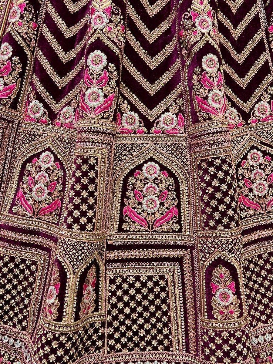 Richly embroidered maroon velvet lehenga with pink floral and gold zari work, perfect for Indian ethnic wear.