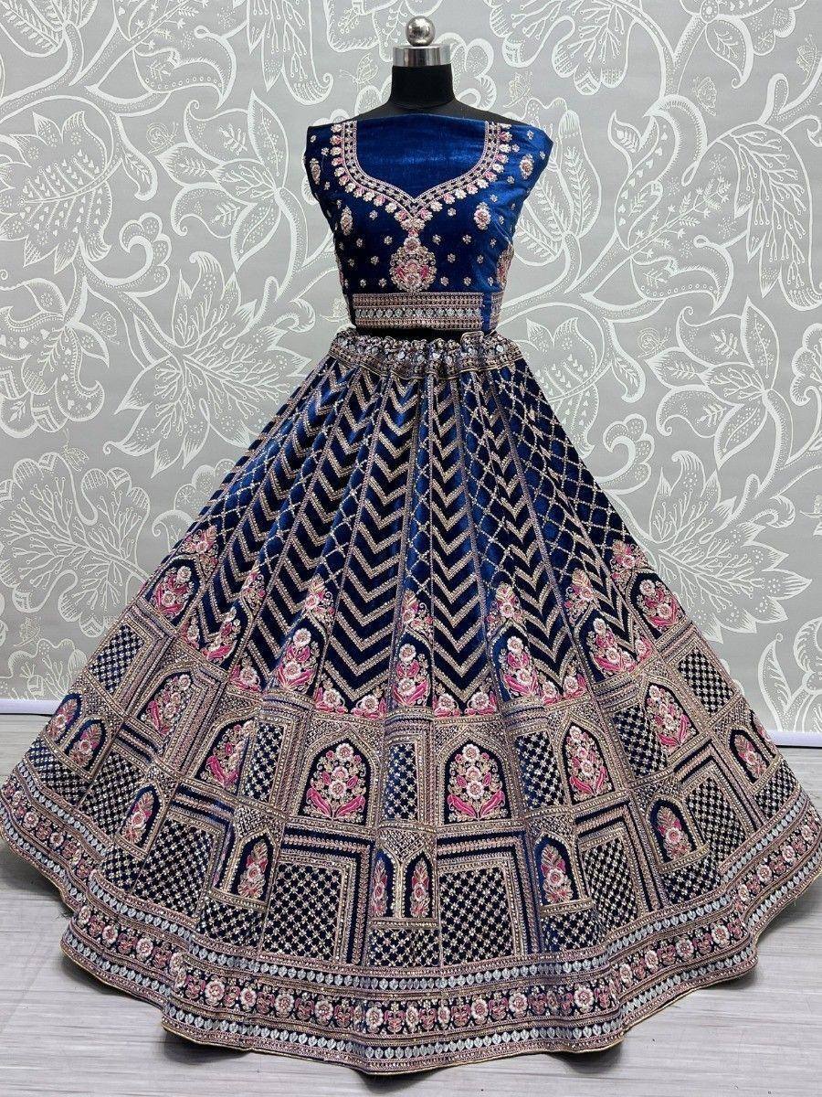 Royal blue velvet lehenga choli with intricate gold and pink embroidery, perfect for weddings and festive occasions.