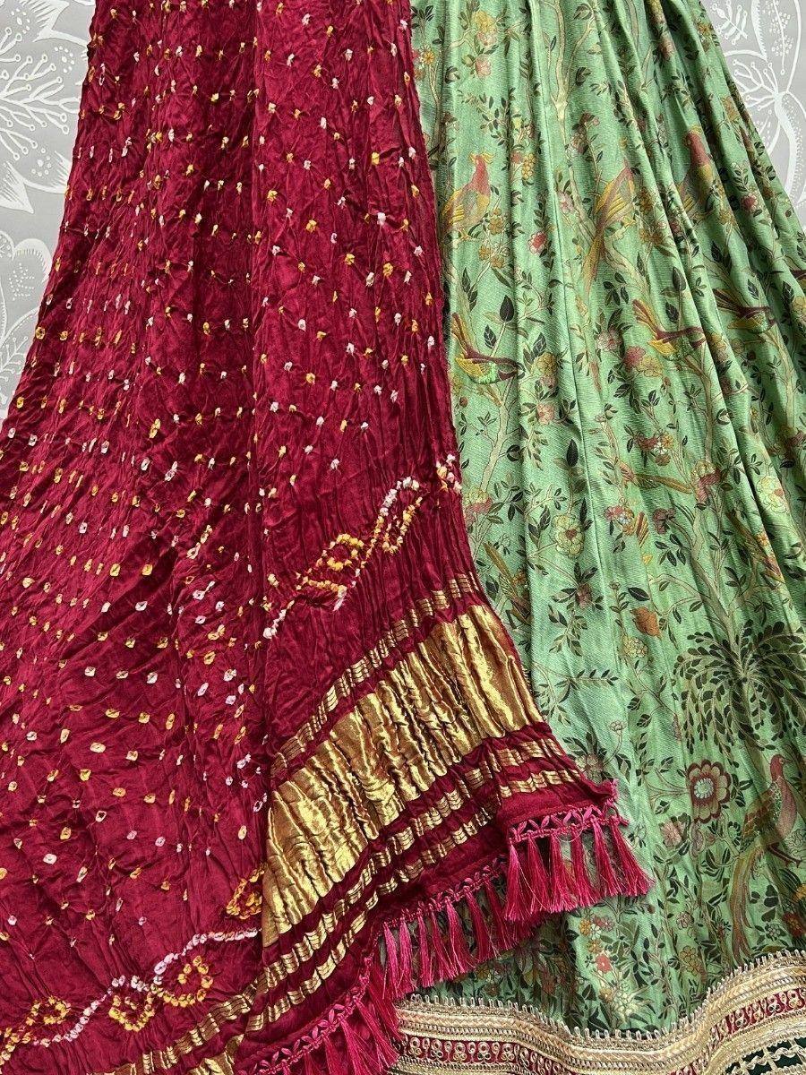 Maroon and green ethnic lehenga skirts with floral embroidery and gold trim, perfect for Indian weddings