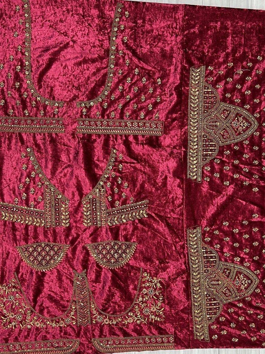 Rich maroon velvet lehenga choli fabric with intricate gold embroidery and embellished borders