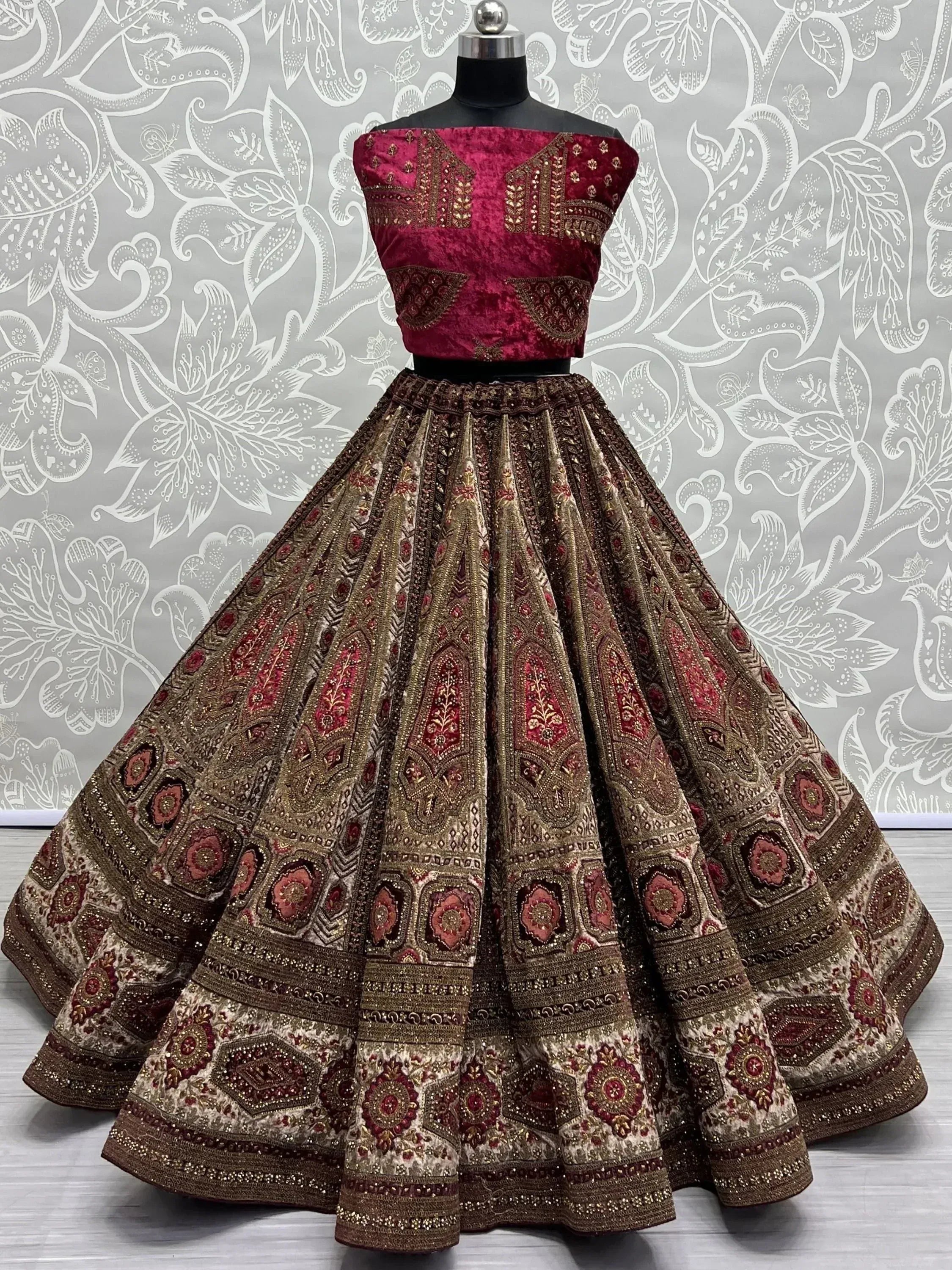 Maroon velvet off-shoulder lehenga choli with heavy gold embroidery and floral motifs, perfect for Indian weddings.
