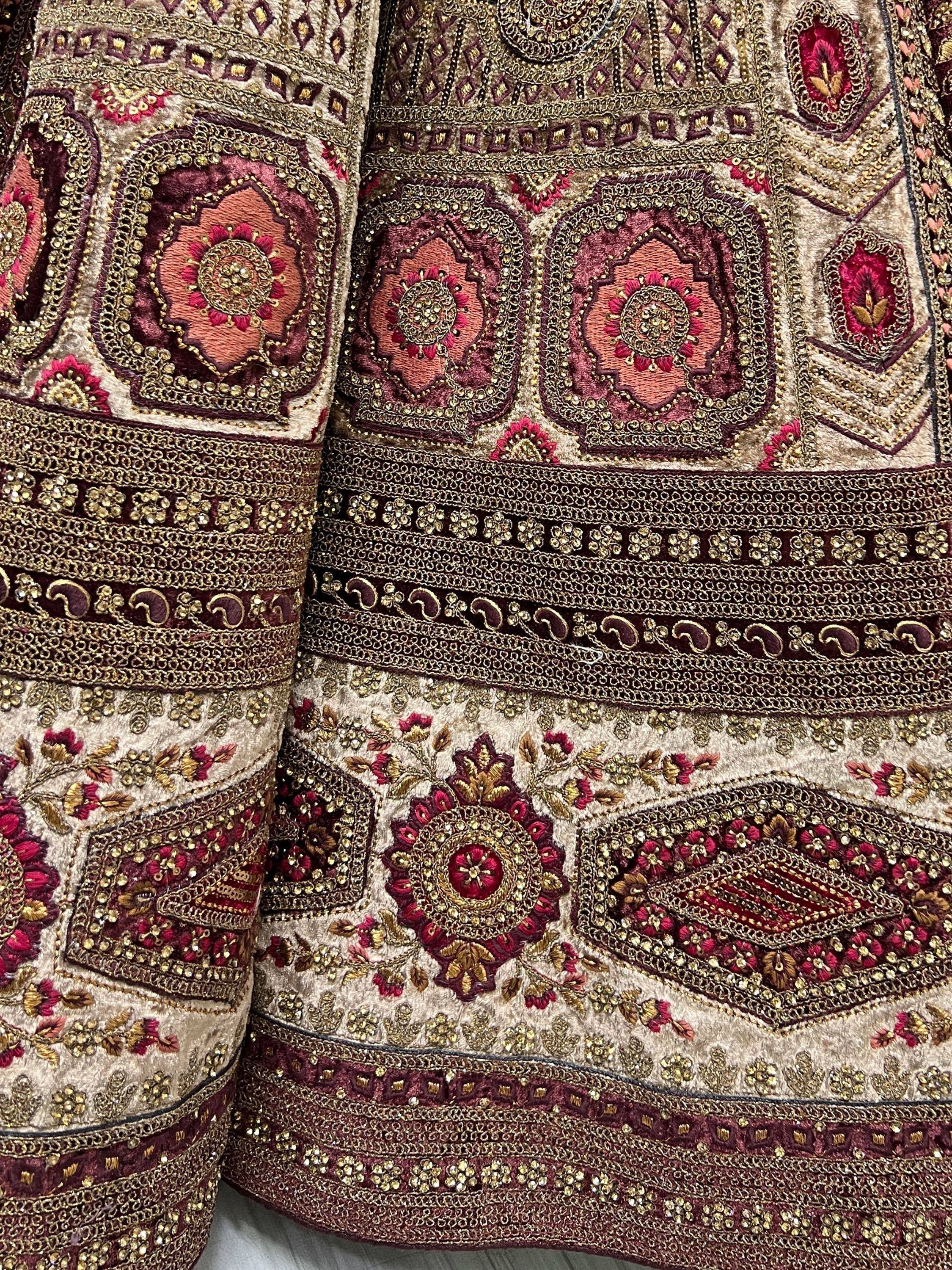 Richly embroidered Indian ethnic wear with gold and maroon floral patterns, perfect for festive occasions.