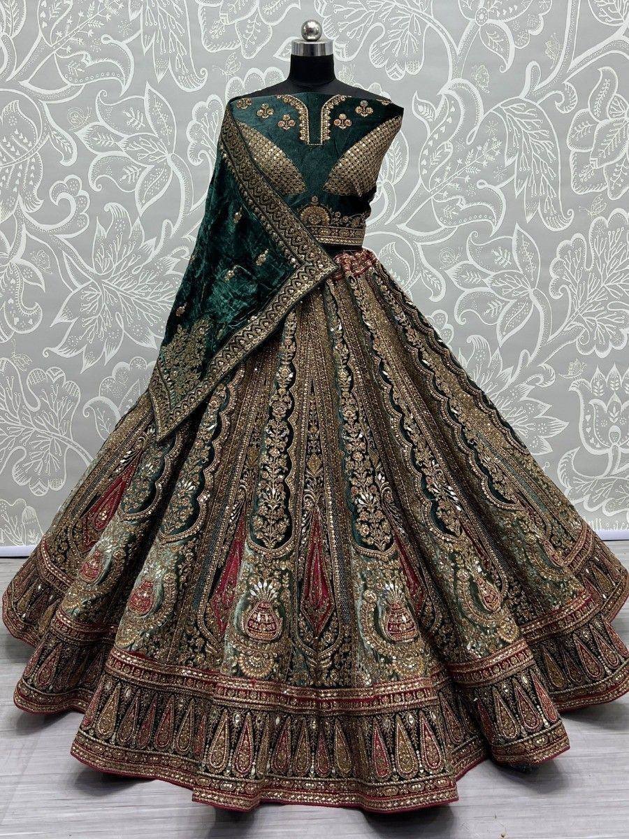 Emerald green velvet lehenga choli with heavy gold embroidery and red accents, perfect for Indian weddings.