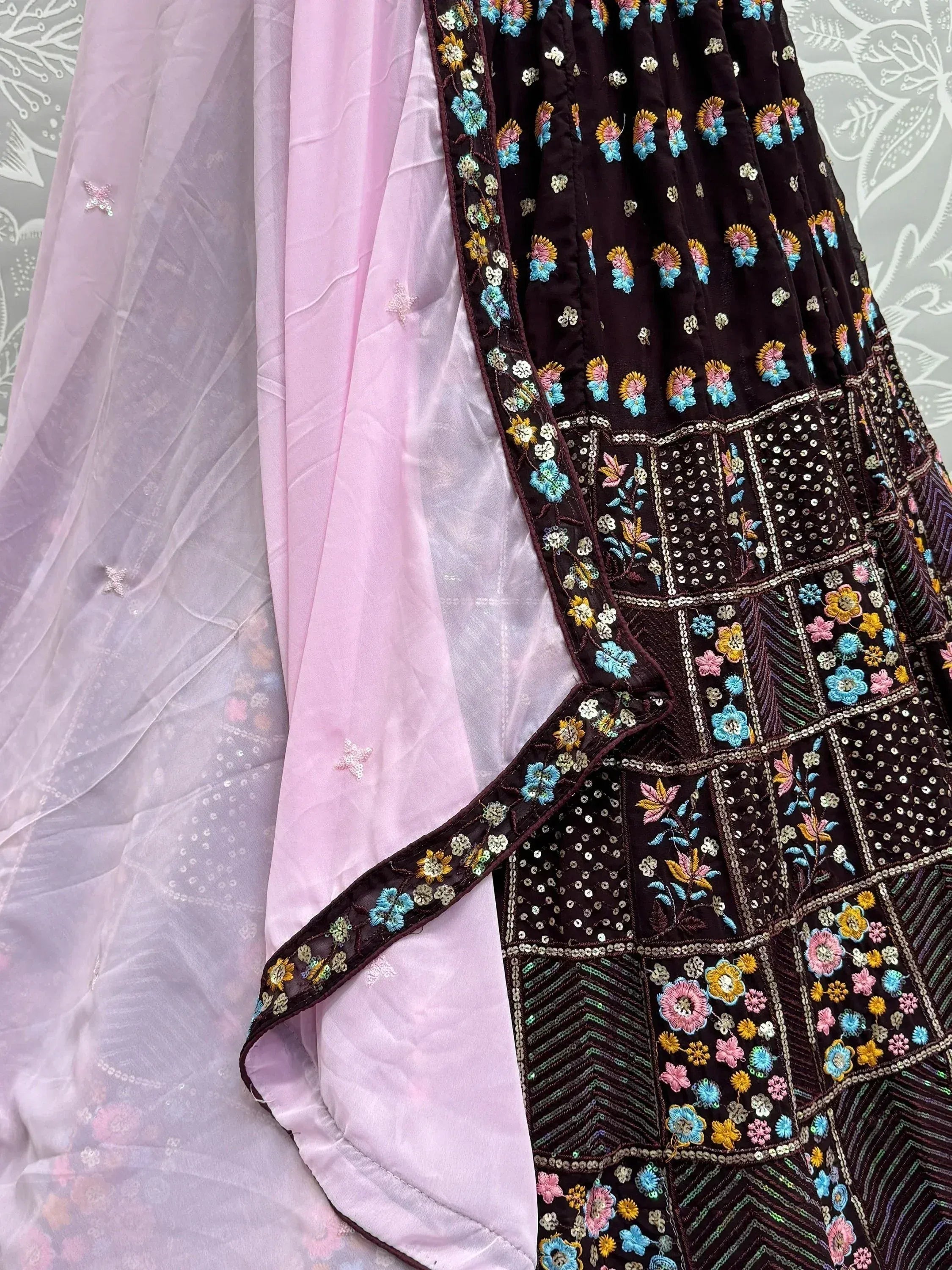 Dark embroidered lehenga with floral motifs and pink sheer dupatta, Indian ethnic wear