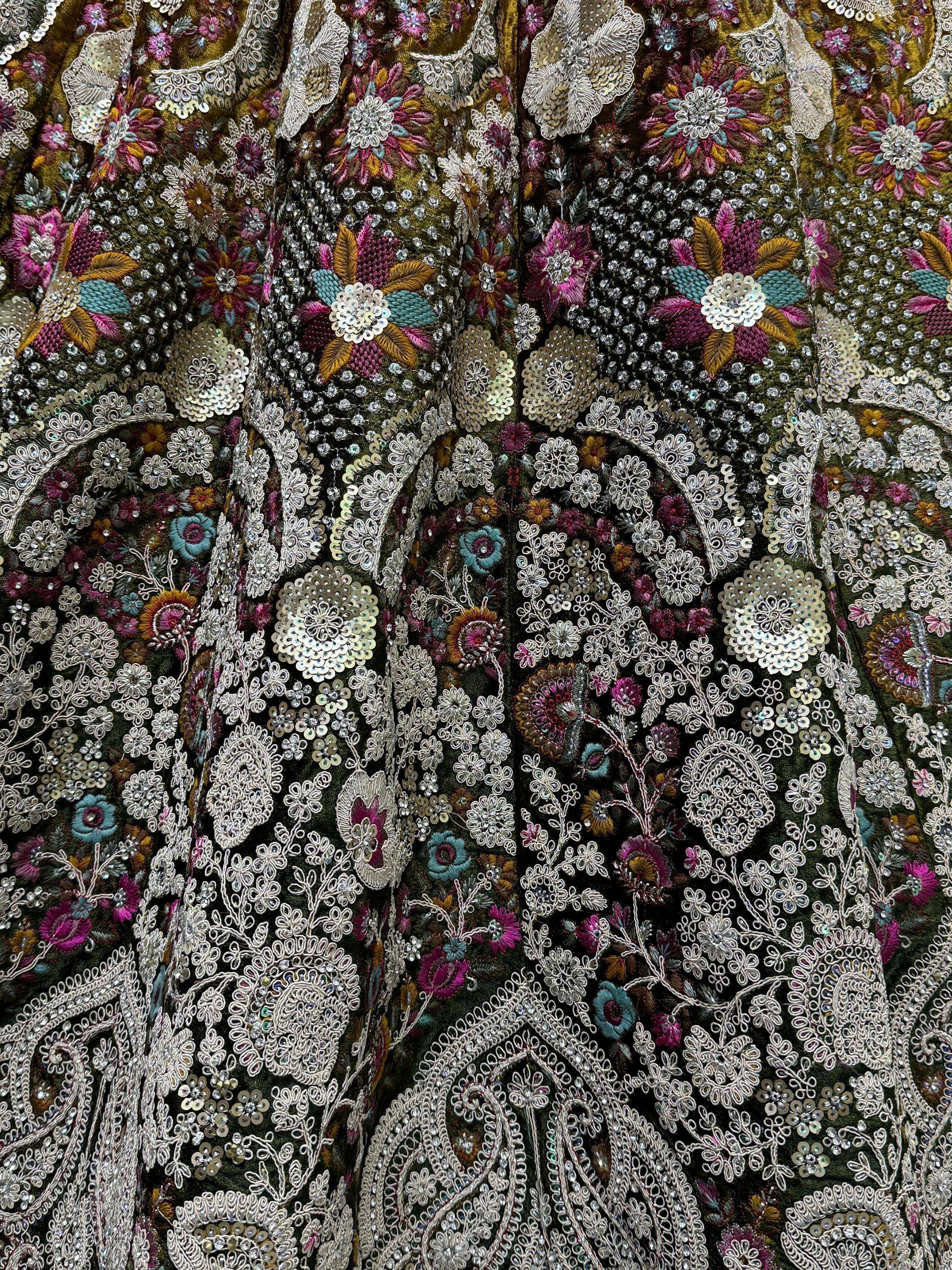 Luxury Indian ethnic wear with intricate floral embroidery, sequins, and beadwork on dark fabric.