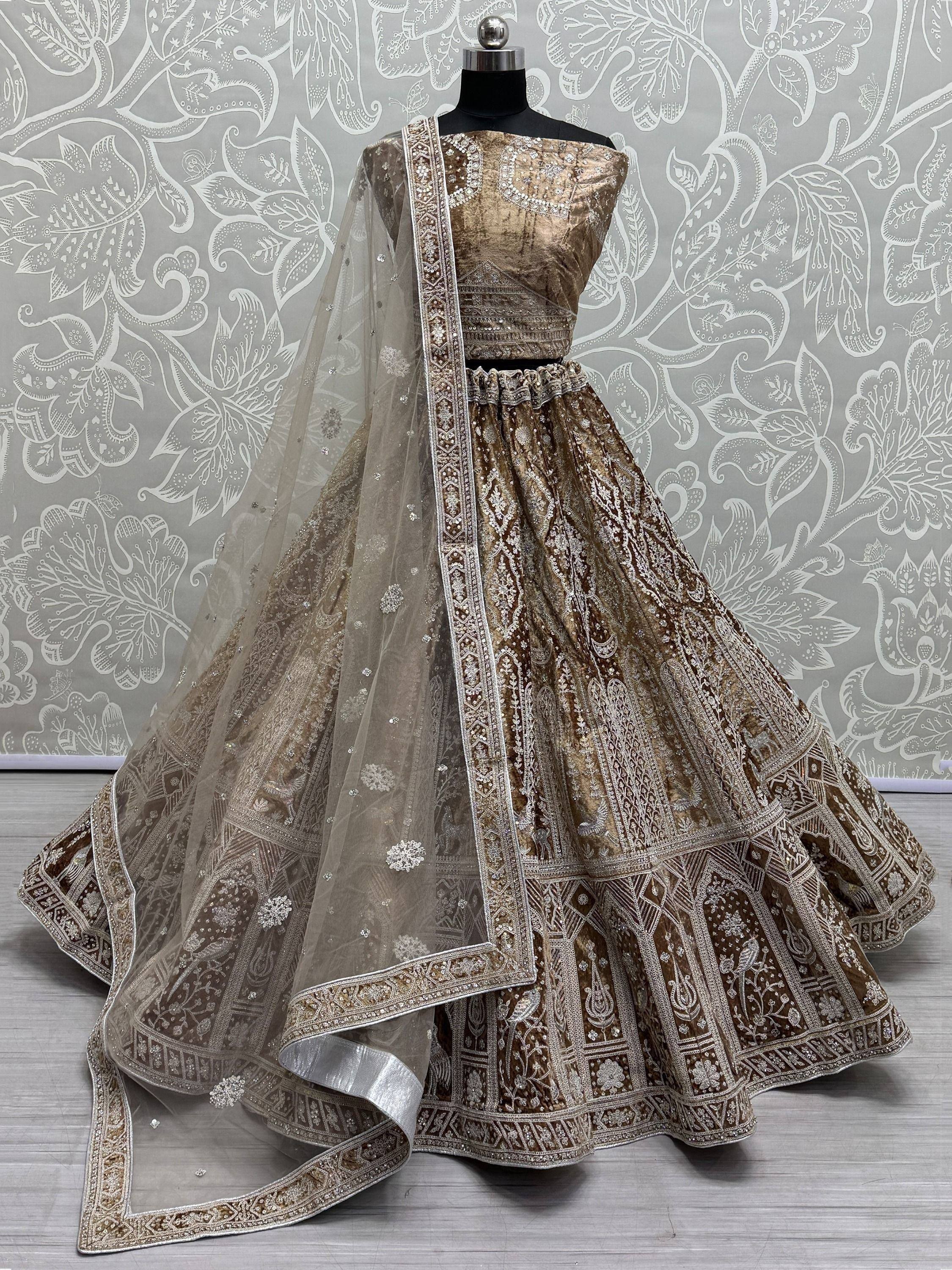 Elegant gold velvet lehenga choli with intricate embroidery and sheer dupatta, perfect for Indian weddings and festive occasions.