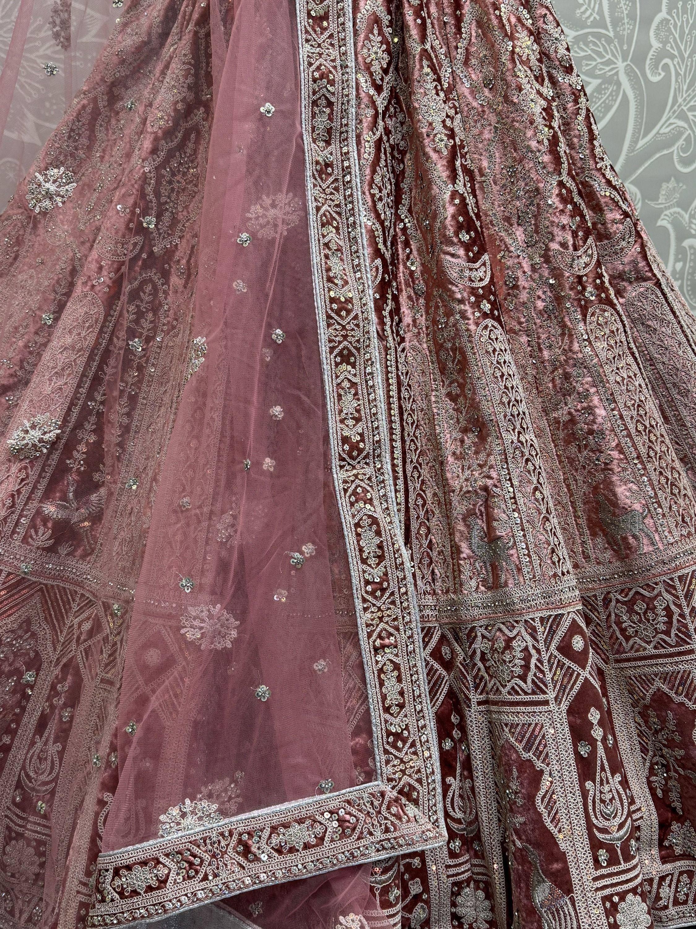 Dusty rose velvet lehenga choli with intricate silver embroidery and sequin detailing, perfect for Indian weddings.