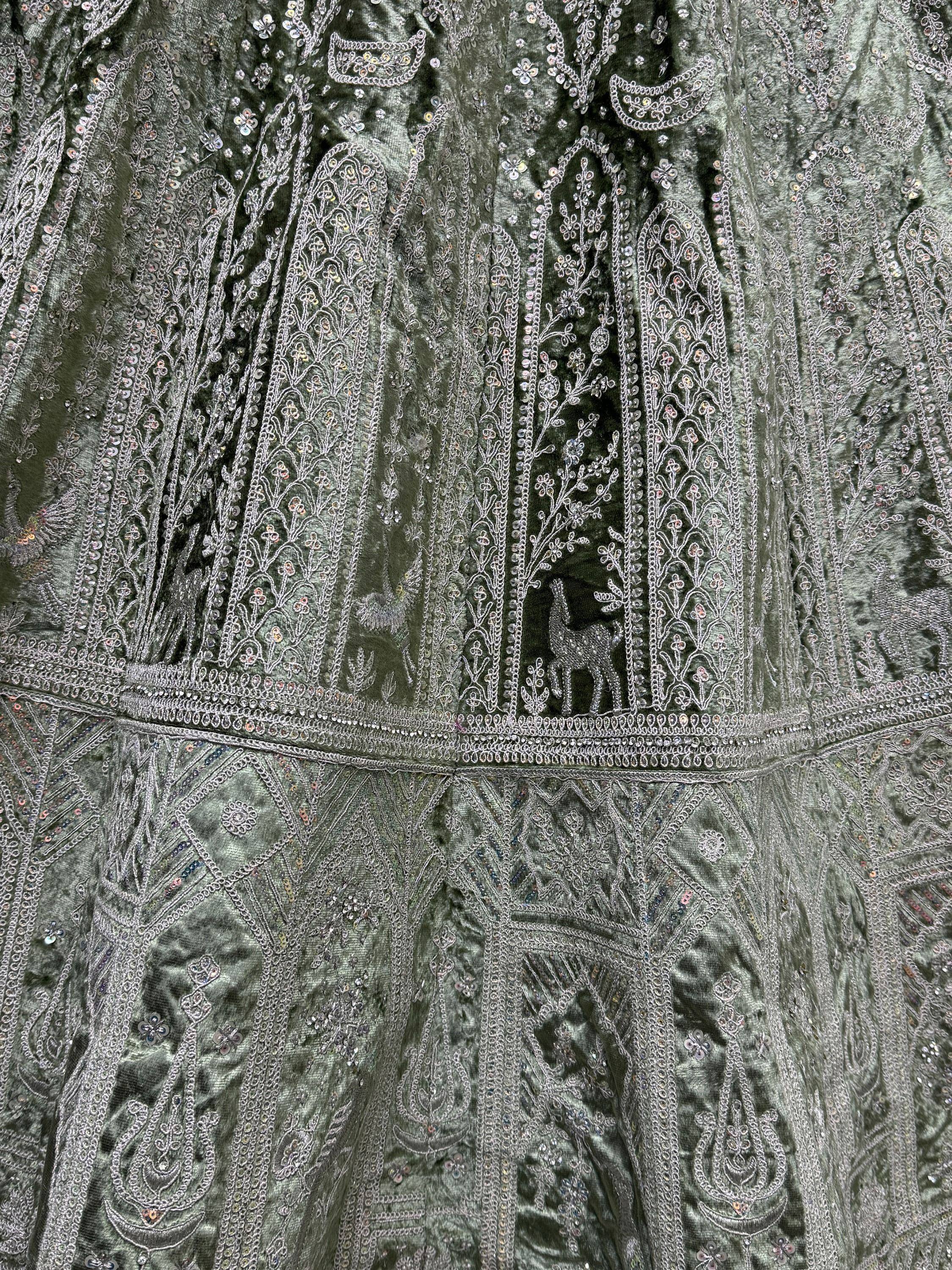 Olive green velvet ethnic gown with intricate silver embroidery and sequin detailing, featuring deer motifs.