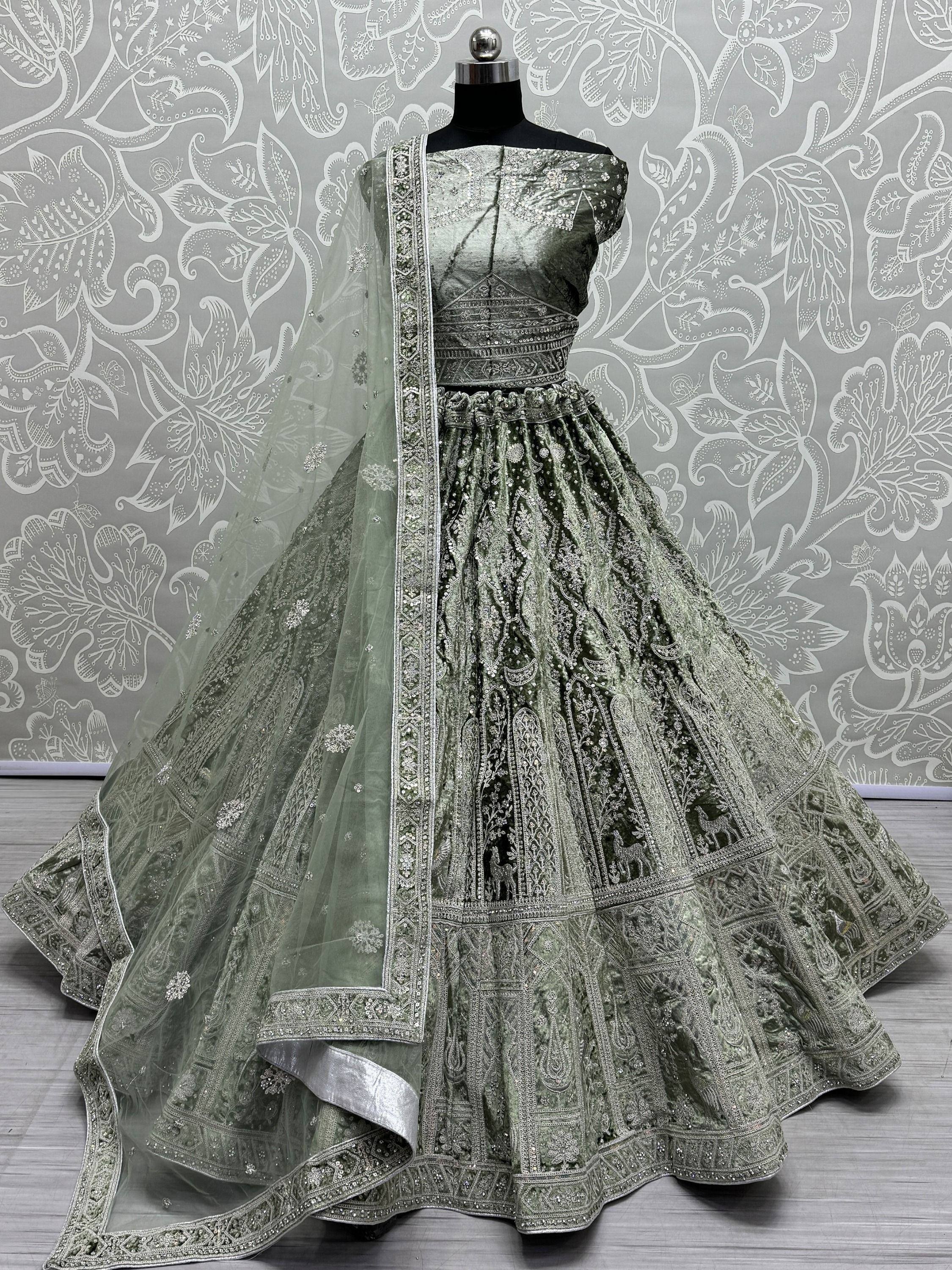 Green velvet designer lehenga choli with heavy embroidery and net dupatta, perfect for Indian weddings and festive occasions.