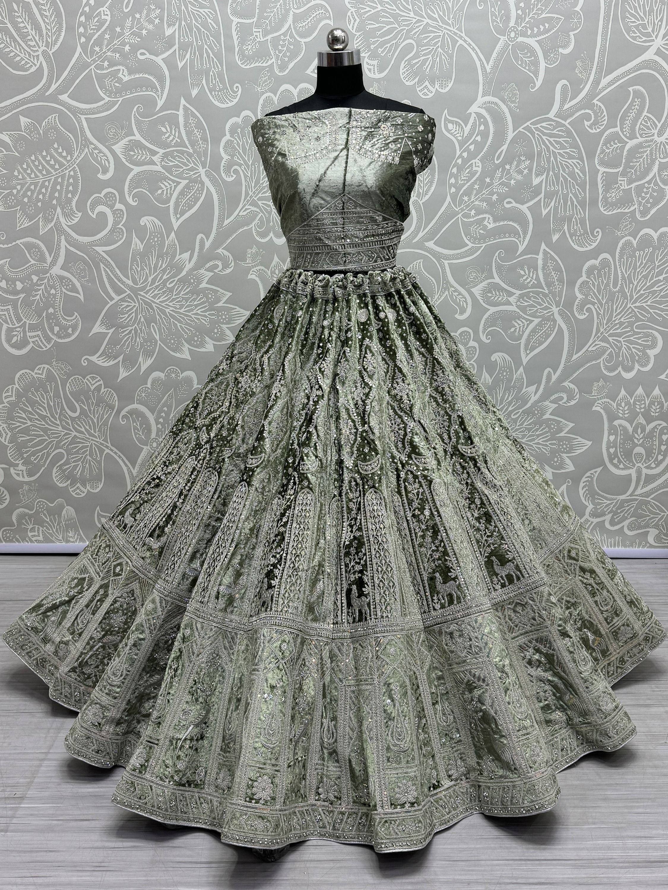 Olive green velvet lehenga choli with intricate silver embroidery and embellished skirt, perfect for Indian ethnic occasions.