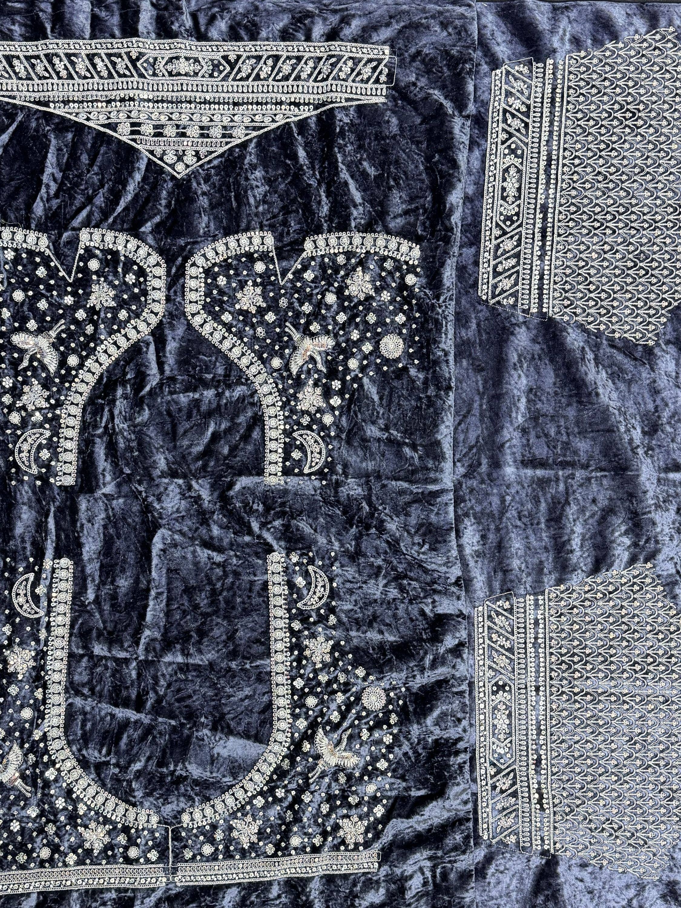 Dark velvet Indian ethnic wear with intricate gold embroidery and mirror work details.