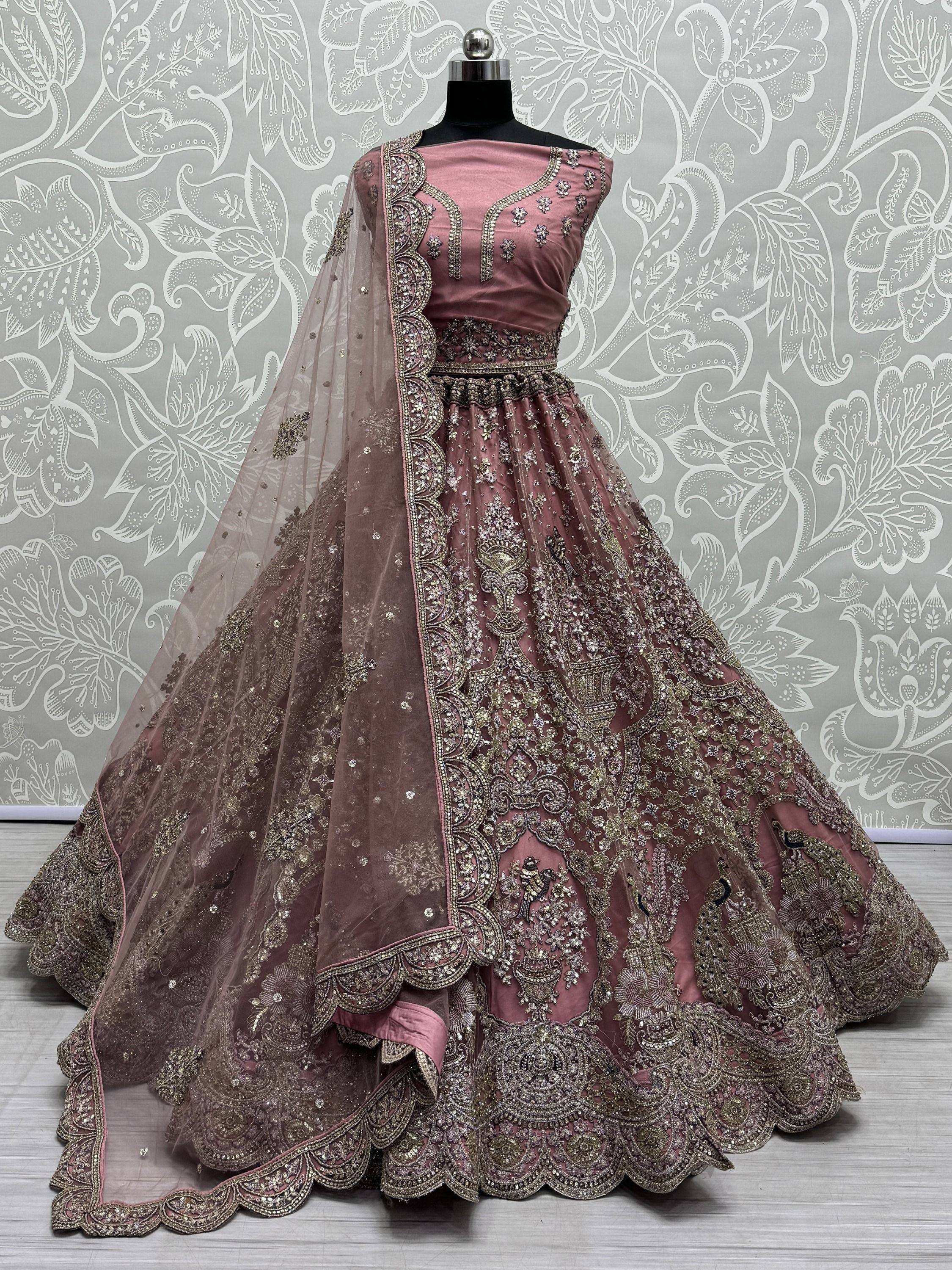 Dusty pink designer lehenga choli with heavy gold embroidery and net dupatta, perfect for weddings and festivals