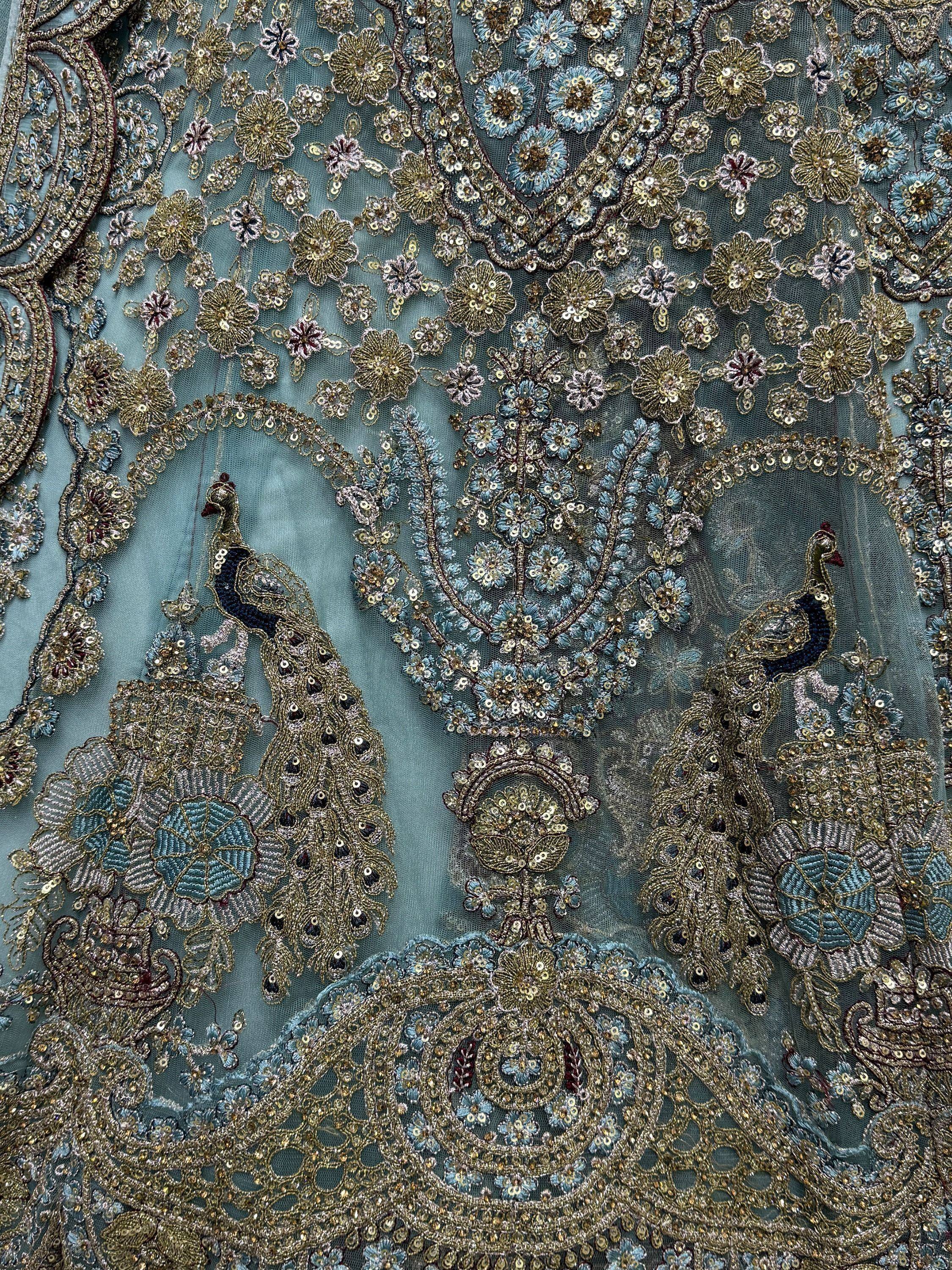 Exquisite peacock embroidery on teal ethnic wear with gold sequins and floral motifs