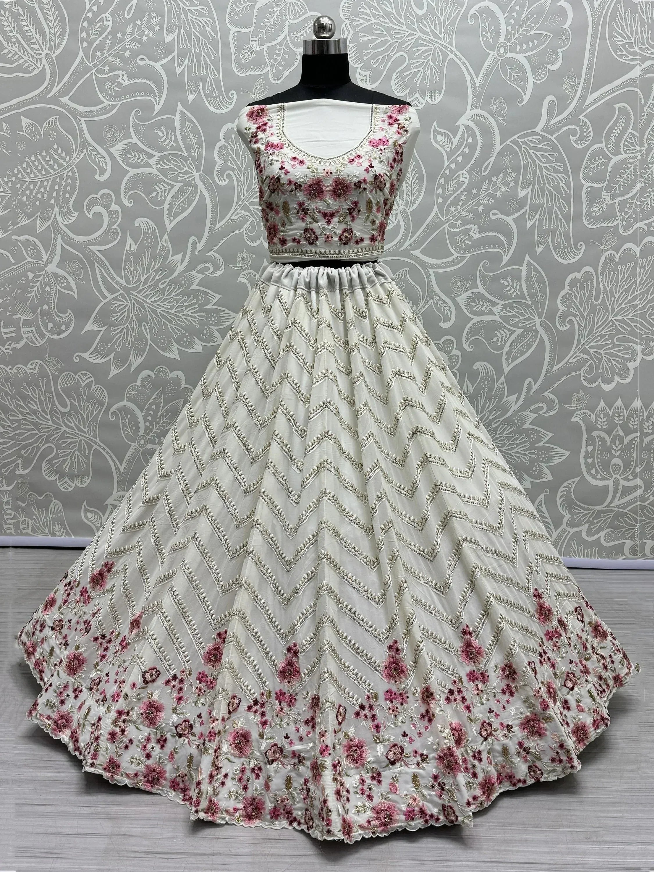 White lehenga choli with pink floral embroidery and silver chevron detailing, perfect for Indian ethnic wear.