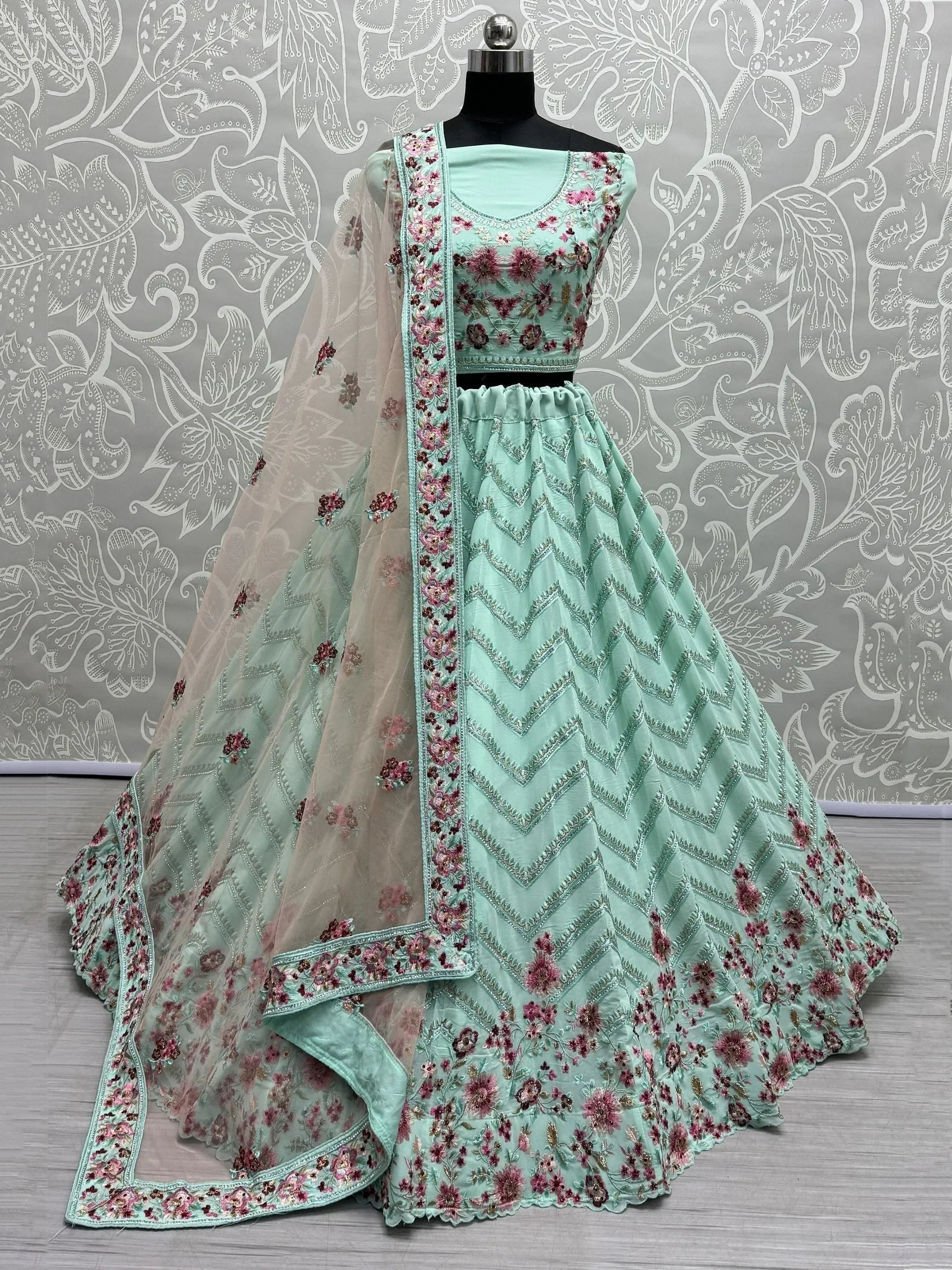 Mint green lehenga choli with floral embroidery and chevron patterns, perfect for Indian ethnic wear.