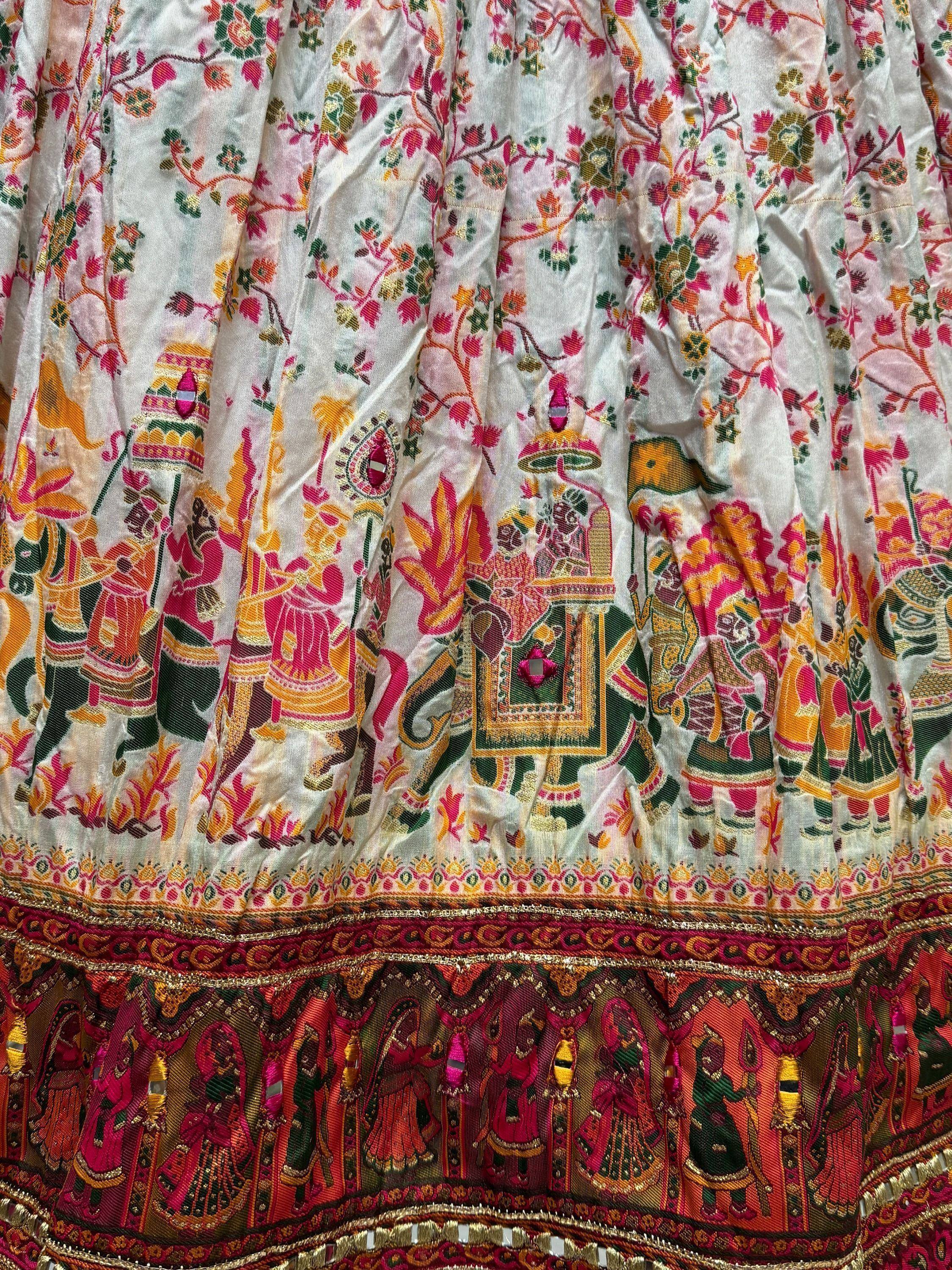 White ethnic lehenga with vibrant floral and royal court embroidery, perfect for Indian weddings and festivals.