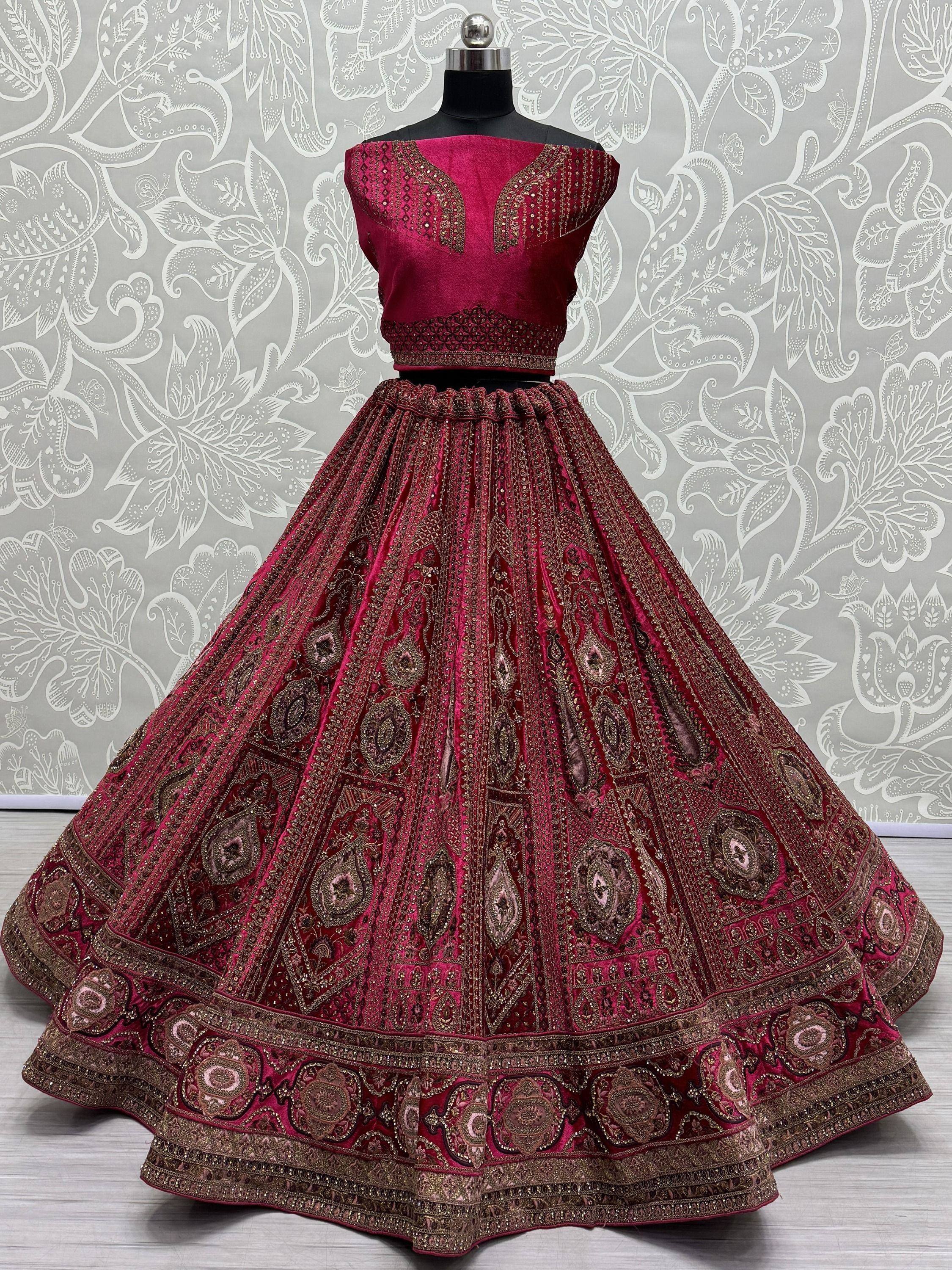Rich maroon velvet lehenga choli with intricate gold embroidery, perfect for Indian weddings and festive occasions.