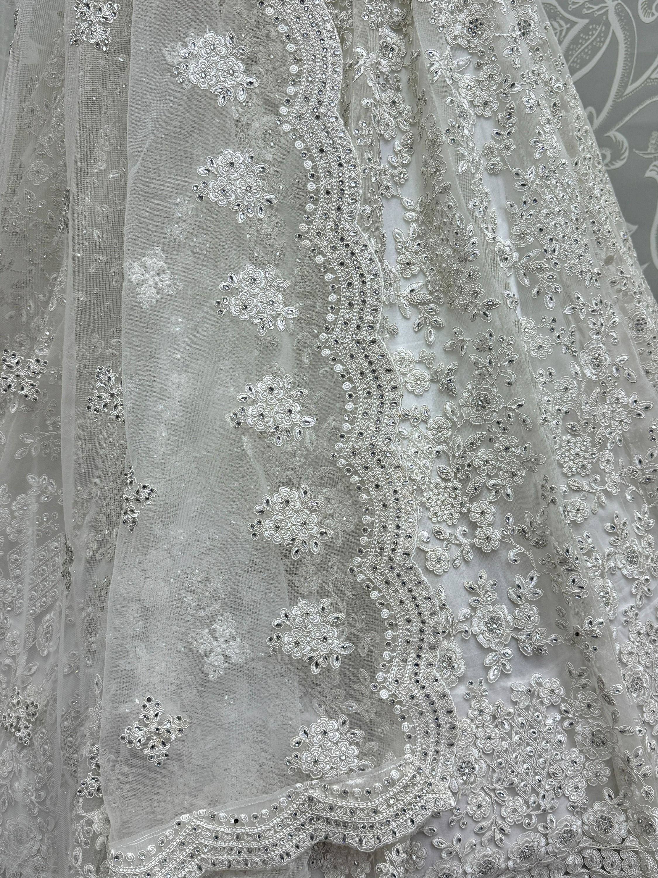 Elegant white ethnic gown with intricate floral embroidery and sequin detailing, perfect for weddings and celebrations.