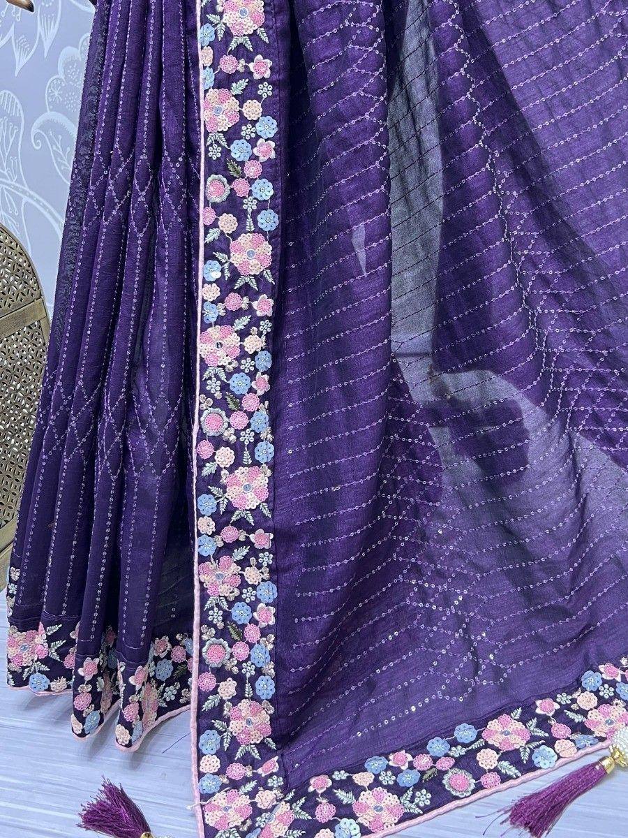 Purple ethnic lehenga with floral embroidery and tassels, perfect for Indian weddings or festive occasions.