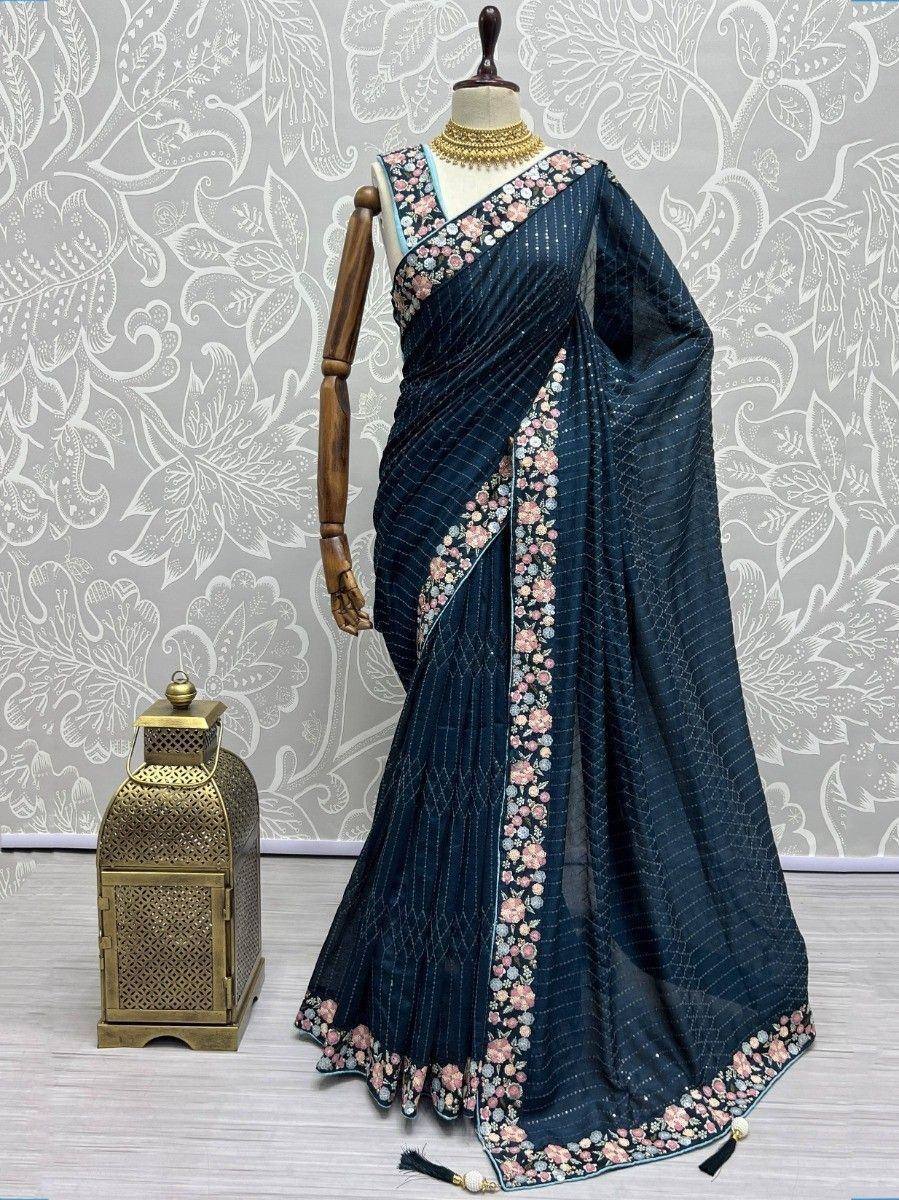Dark blue saree with floral embroidery and gold jewelry, displayed on mannequin for ethnic wear