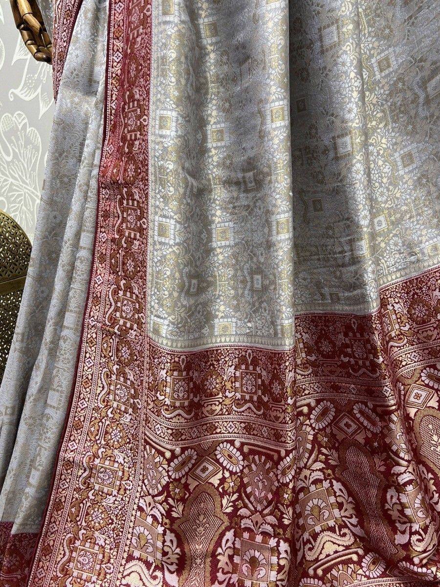Elegant silver and maroon ethnic saree with intricate gold zari work and traditional border design