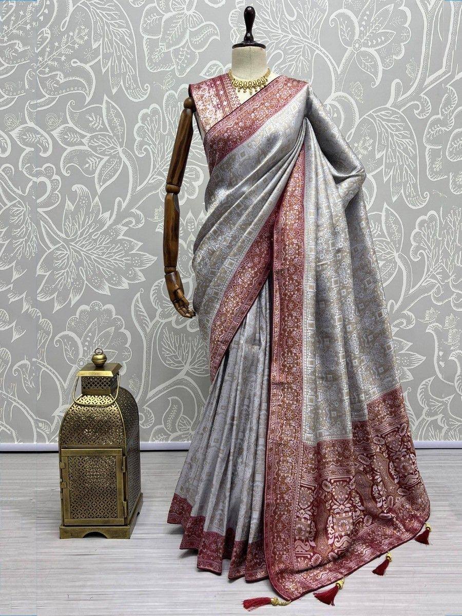 Elegant silver and maroon designer saree with intricate border, displayed on mannequin for ethnic wear