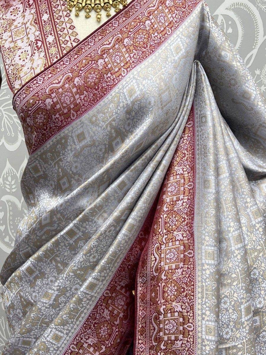 Elegant silver and maroon ethnic saree with intricate gold paisley and geometric patterns, perfect for Indian weddings.