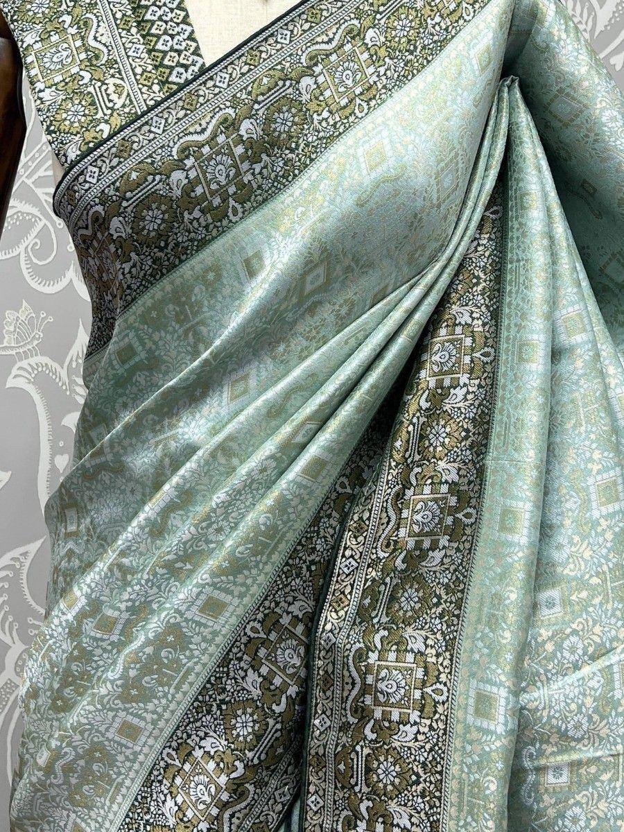 Mint green designer saree with intricate gold and white paisley border, perfect for ethnic wear occasions.