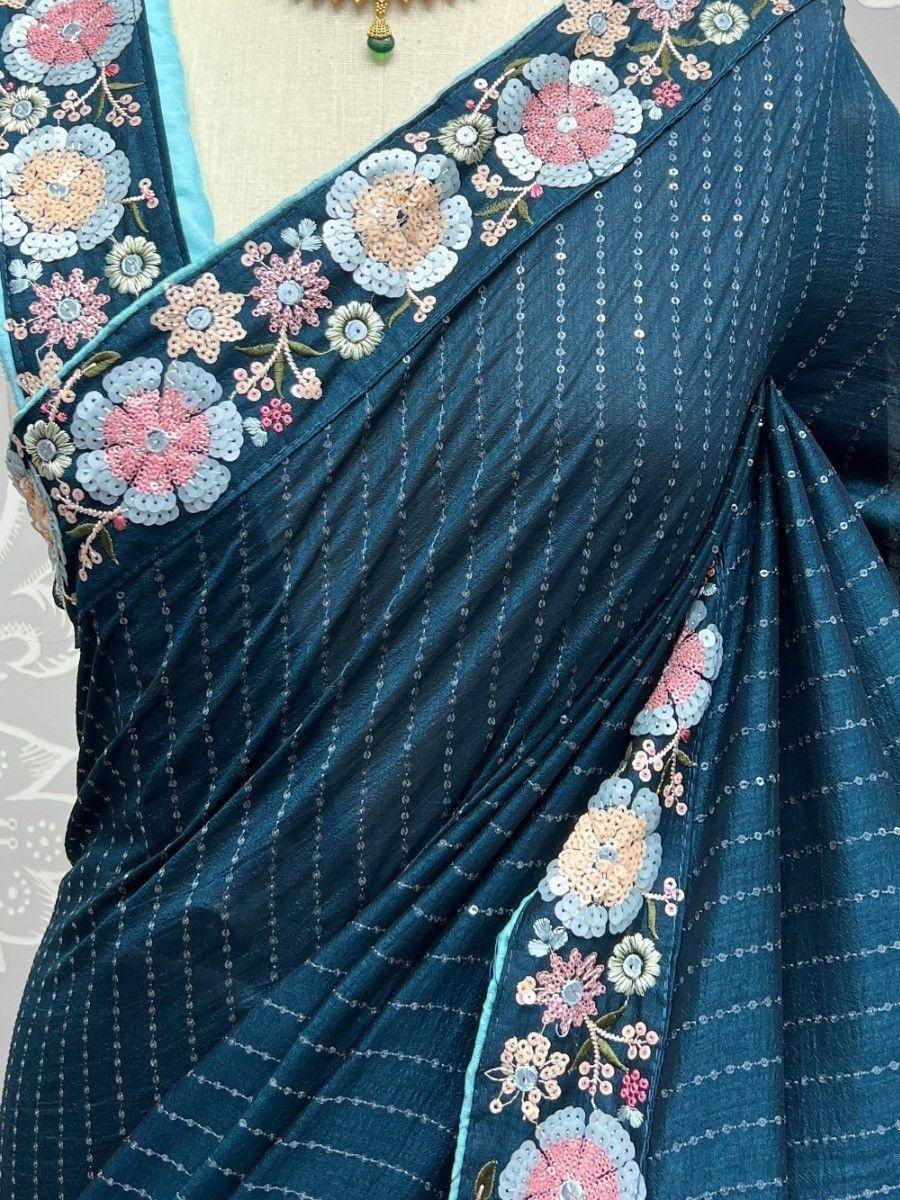 Teal saree with floral embroidery and sequin detailing, perfect for Indian ethnic wear occasions.