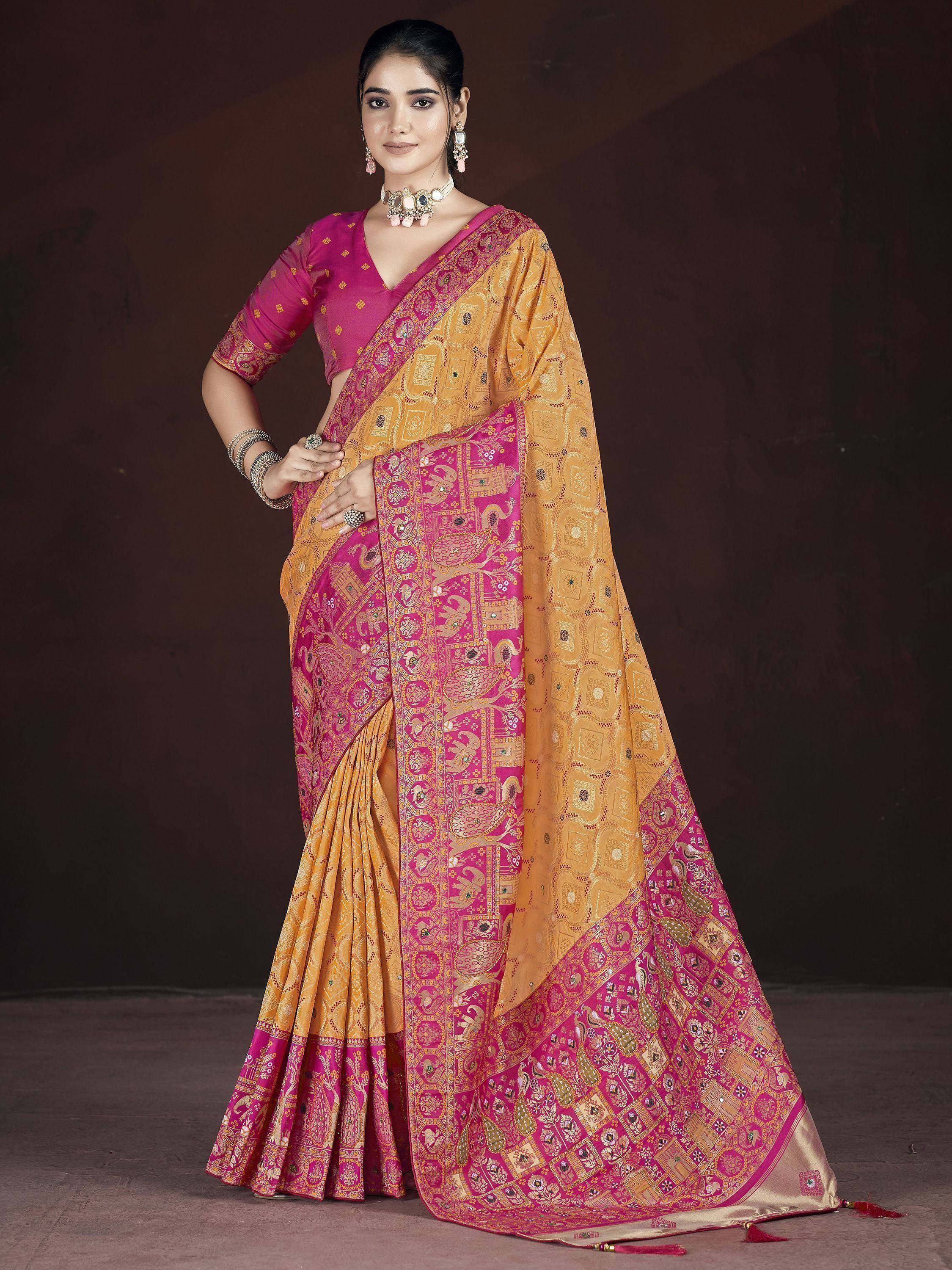 Woman in vibrant pink and gold ethnic saree with intricate paisley and temple motifs, perfect for Indian occasions
