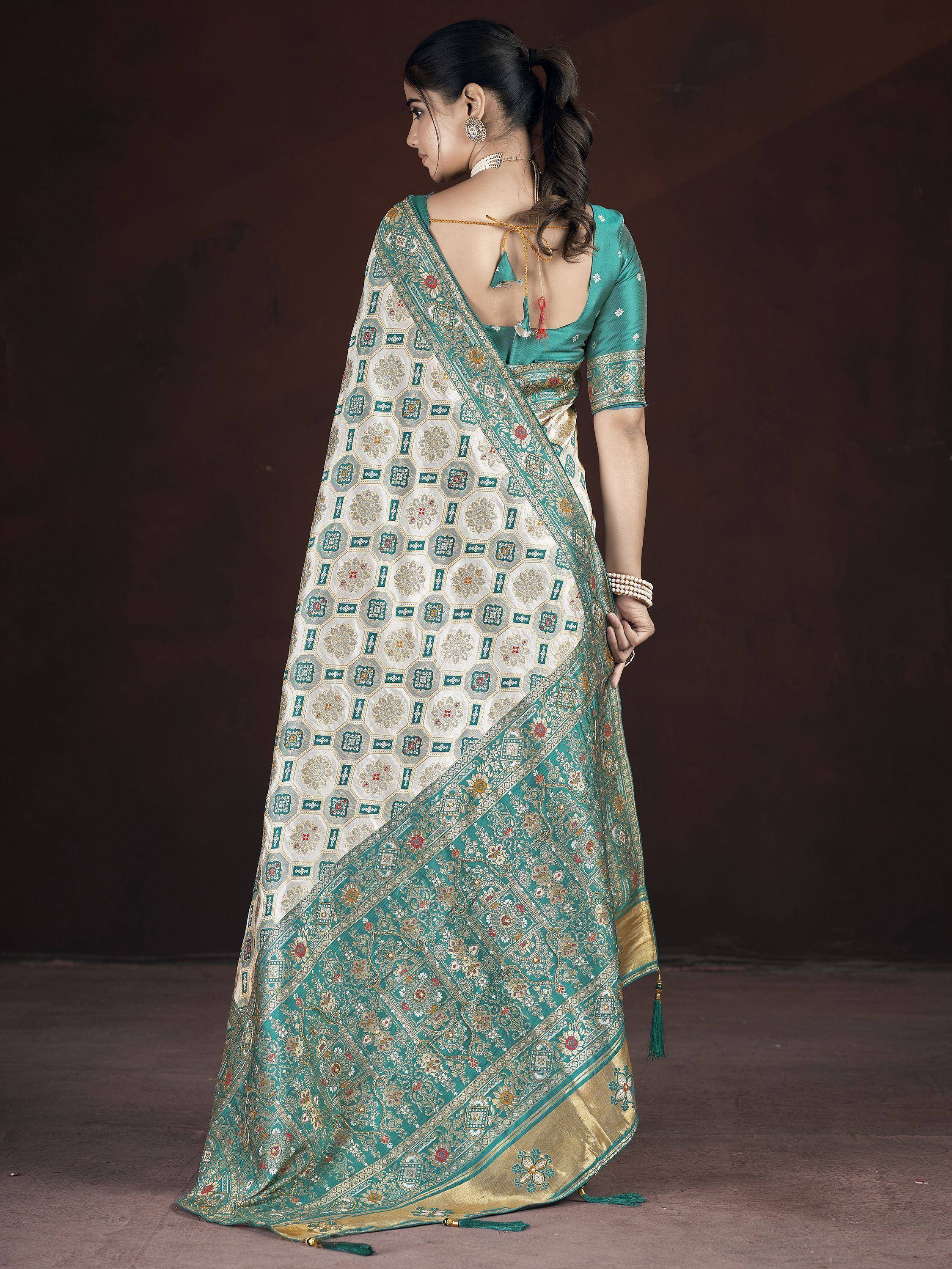Teal and gold designer saree with intricate geometric and floral patterns, perfect for Indian ethnic wear.