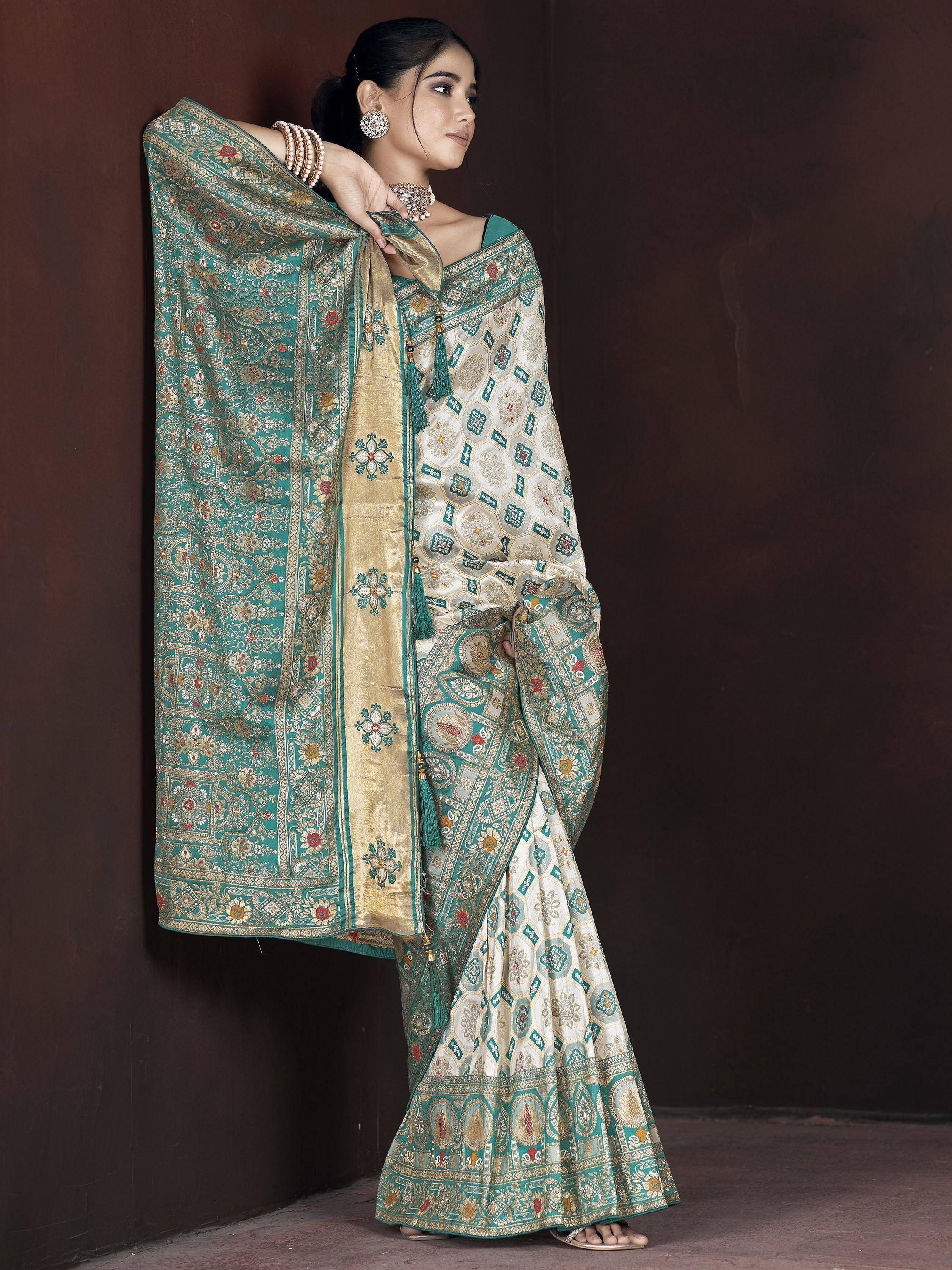 Elegant teal and gold designer saree with intricate floral and geometric patterns, perfect for Indian ethnic wear.