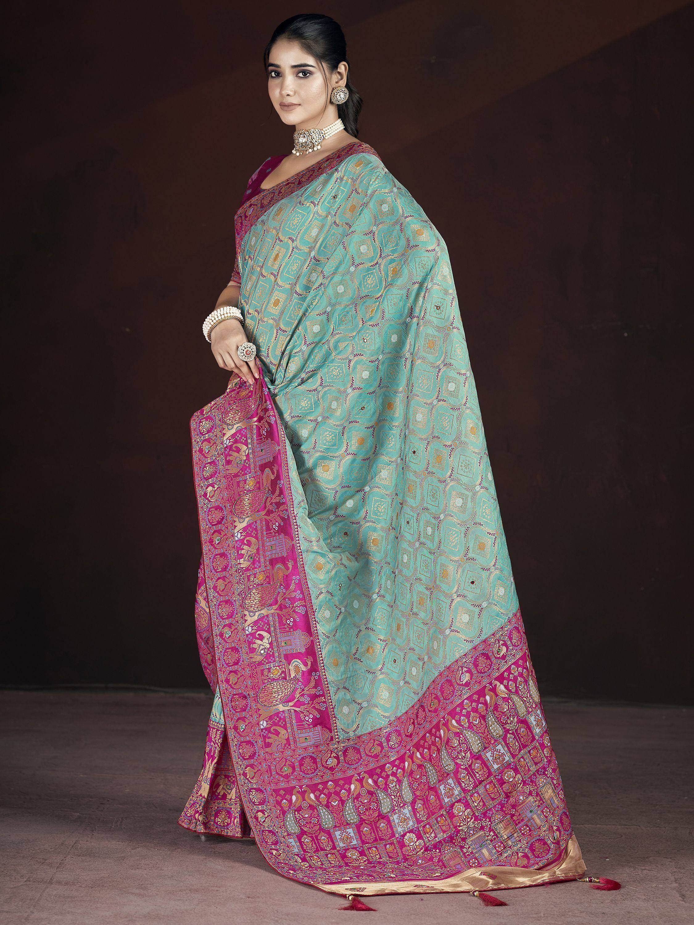 Turquoise and magenta designer saree with intricate gold patterns and traditional Indian motifs, perfect for ethnic occasions.
